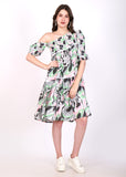 Woman posing in a trendy one-shoulder A-line dress with geometric pastel prints, confidently standing