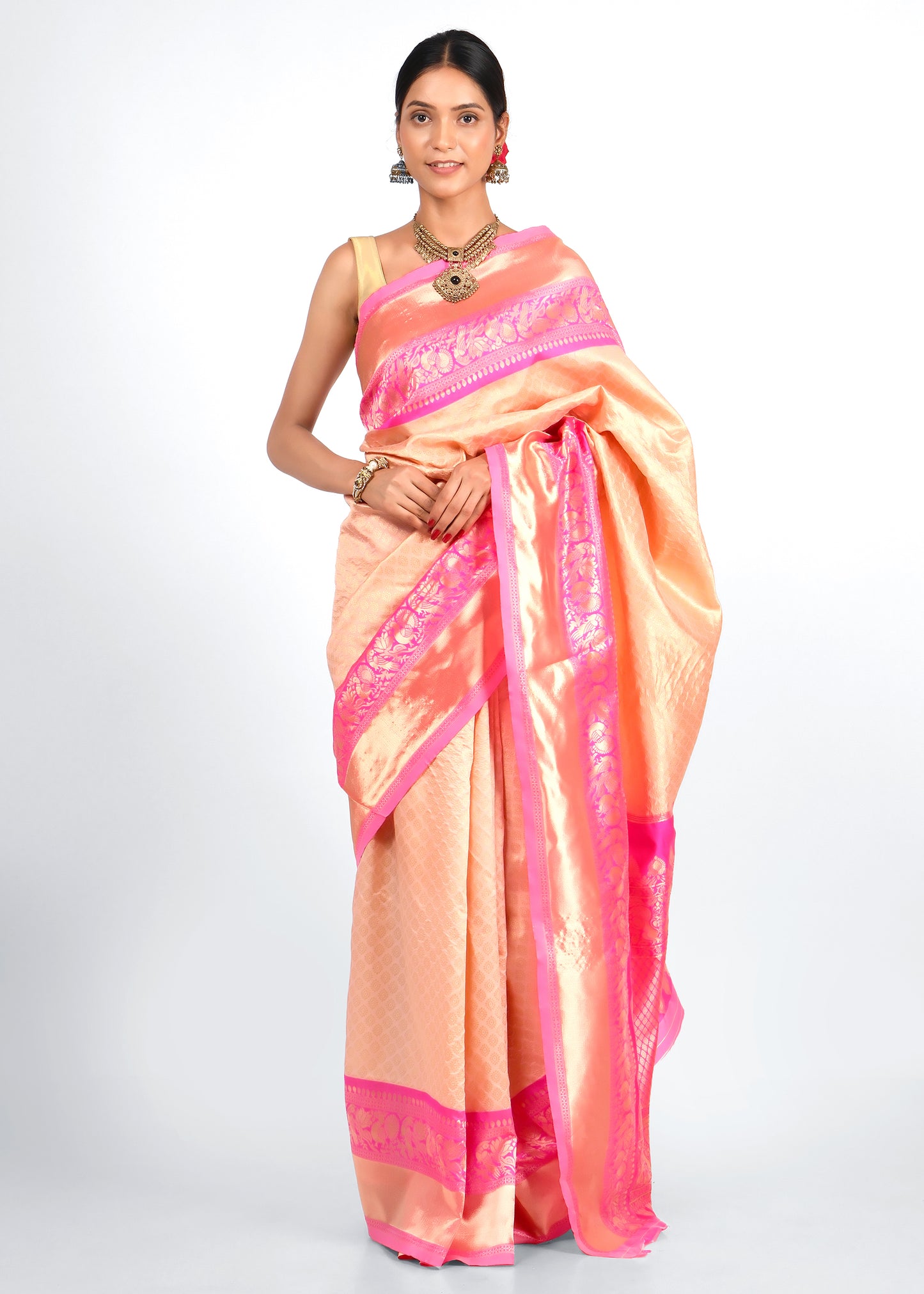 Elegant peach and pink silk saree with intricate floral and paisley motifs, perfect for festive and wedding occasions