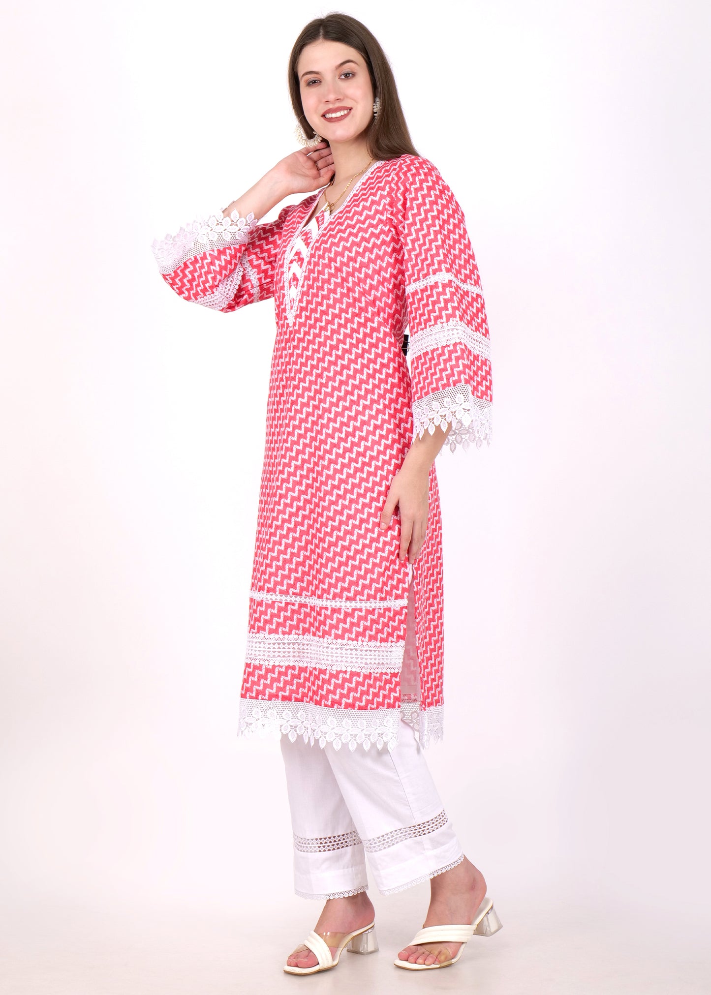 Side profile of a woman in a red and white zigzag kurta, featuring wide lace-embellished sleeves and a chic neckline, styled with white trousers.