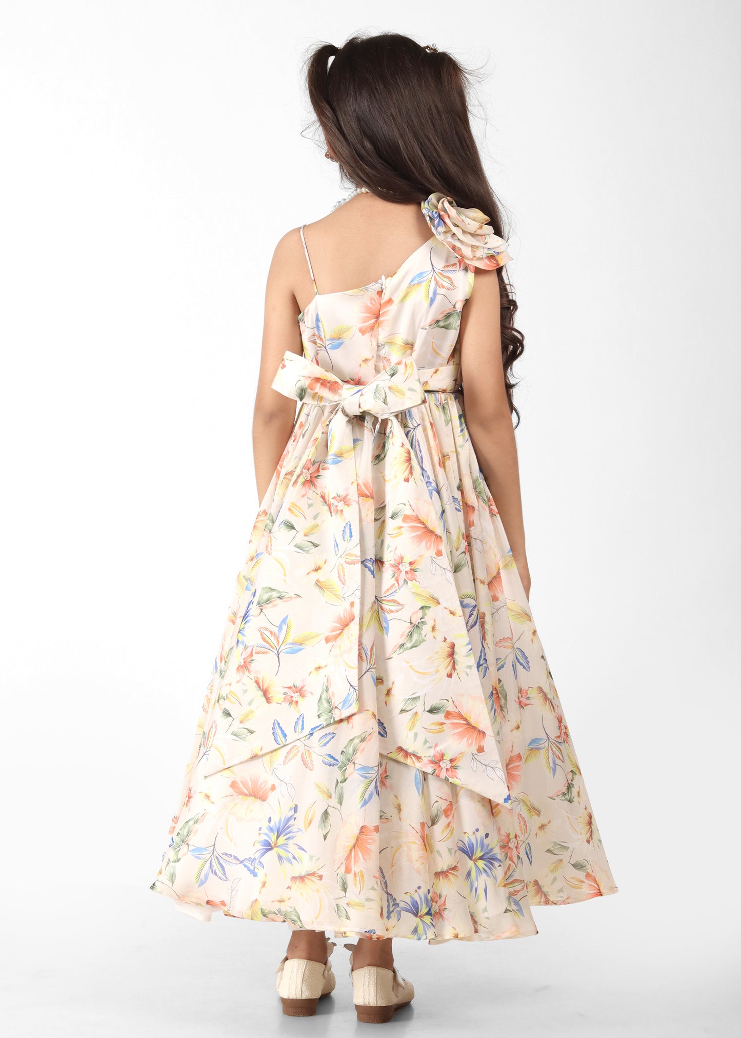 Girl in a pastel floral dress posing with a pleated bodice and flowy skirt, perfect for summer events