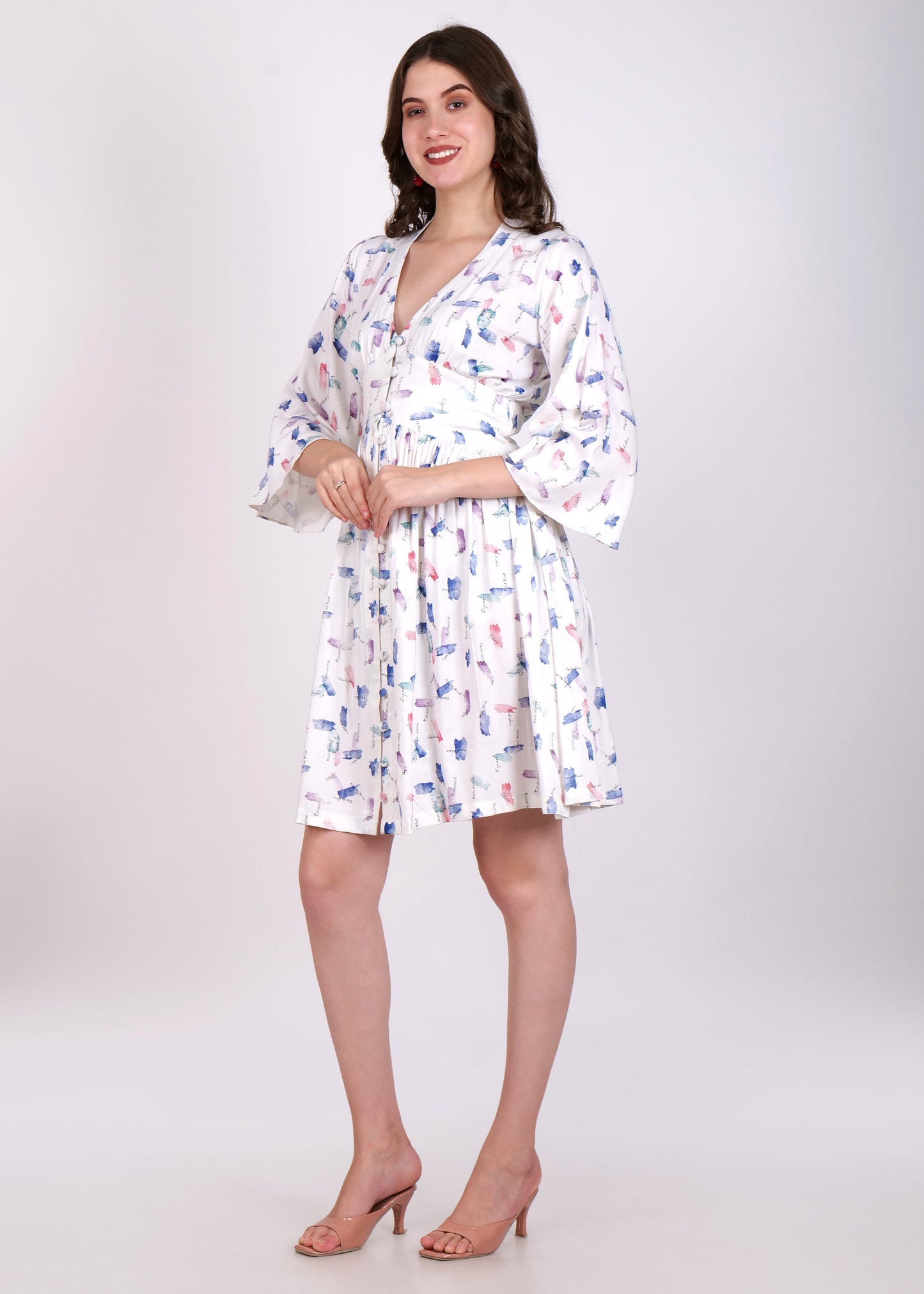 Side View of Woman wearing a white knee-length dress with a floral print, featuring bell sleeves and a deep V-neckline