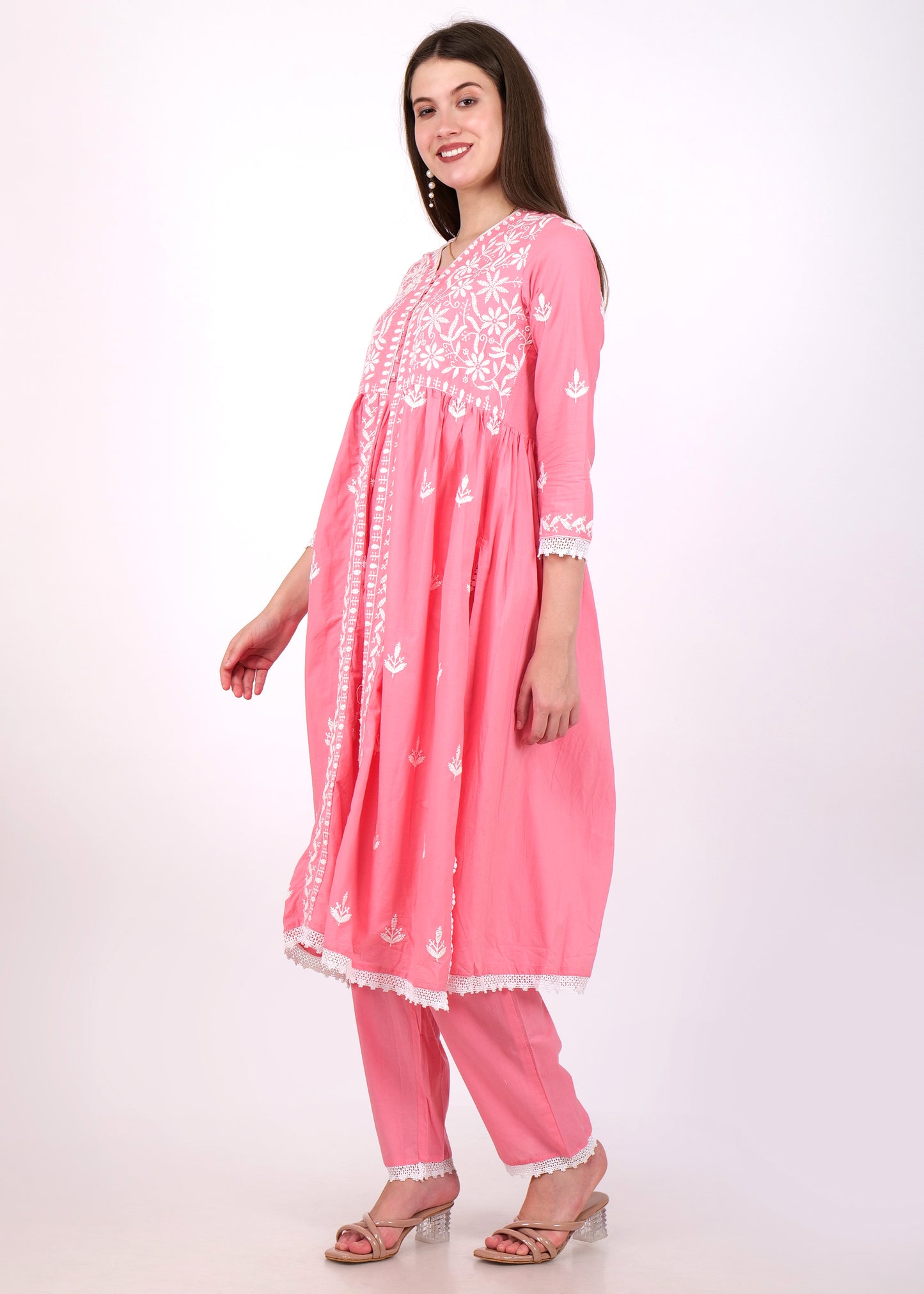 Side view of a woman in a pink Anarkali kurta with delicate white floral embroidery, paired with matching pants.