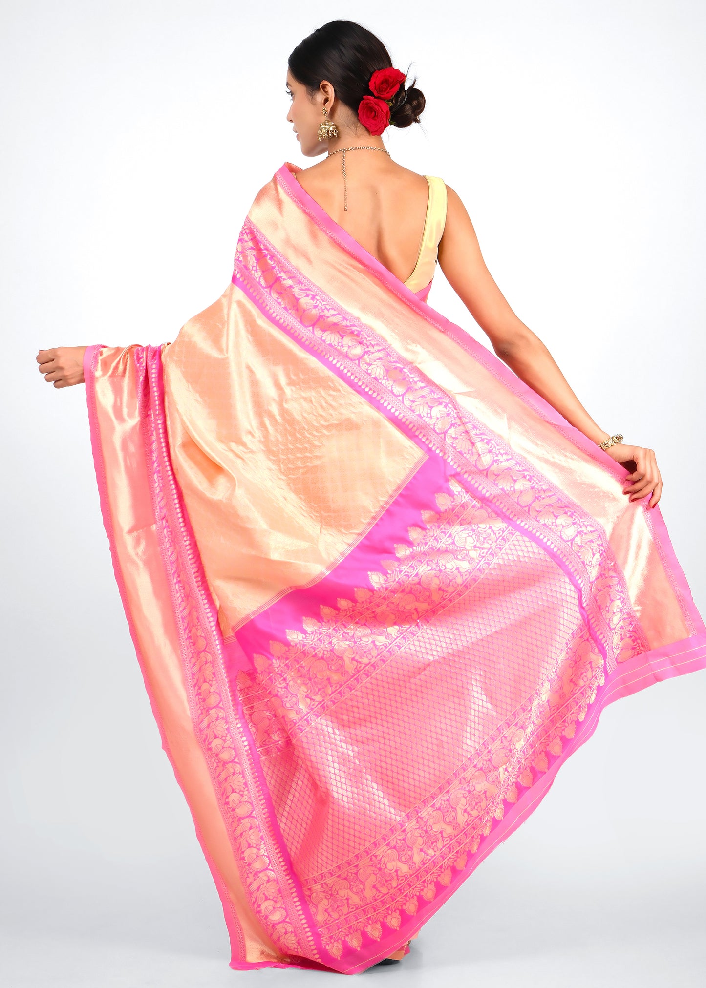 Back view of the peach and pink silk saree showcasing rich zari work and detailed border design