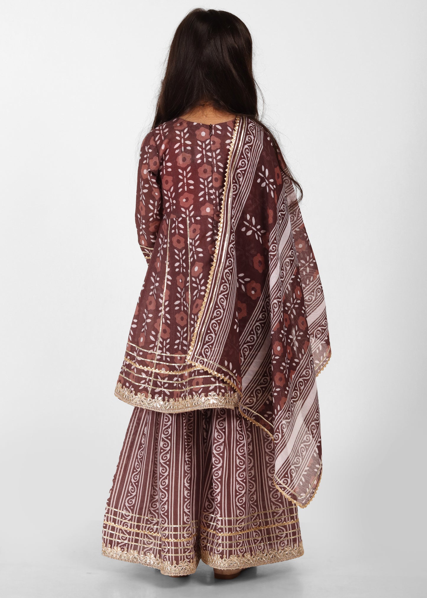 "Back view of a young girl in a maroon ethnic outfit, showcasing detailed embroidery work and traditional design with a flowing dupatta."