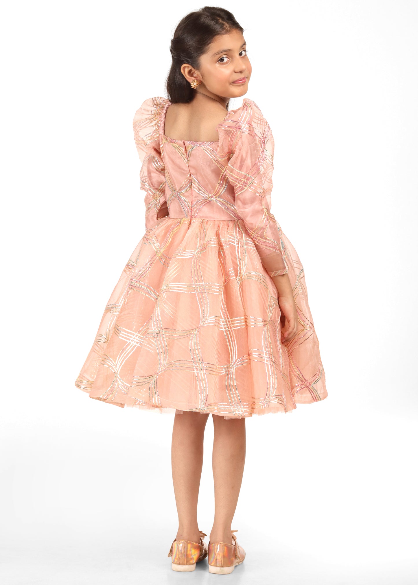 Elegant peach and gold puff sleeve dress worn by a little girl, showing off the back details and sparkling golden patterns.