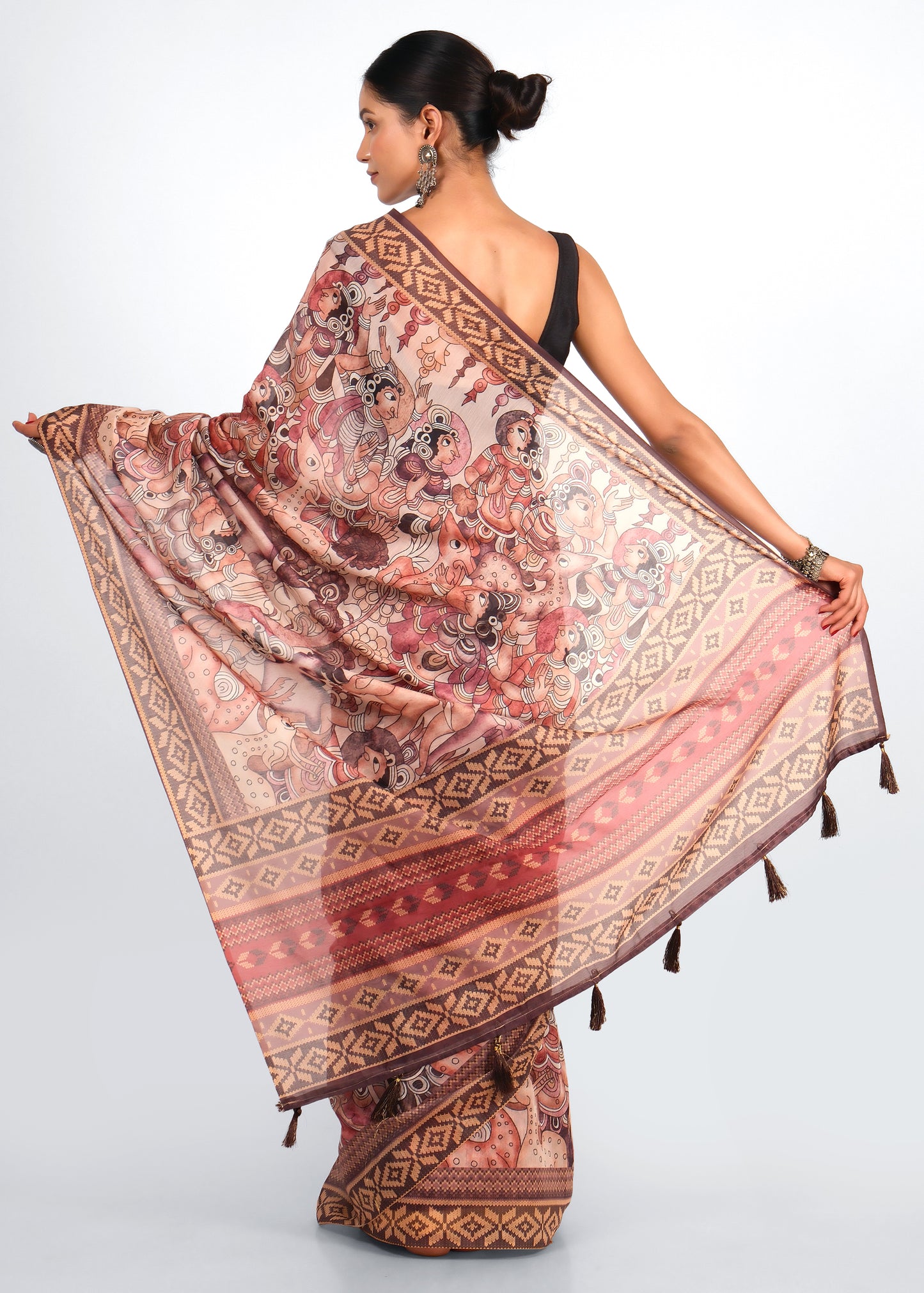 "Back view of a woman draped in a saree featuring mythological Indian characters and artistic motifs, complemented by tassel detailing."