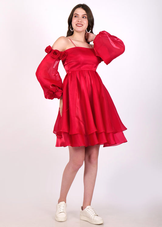 Front view of a woman in a red flowy dress with layered skirt and floral puff sleeves, giving a confident pose.
