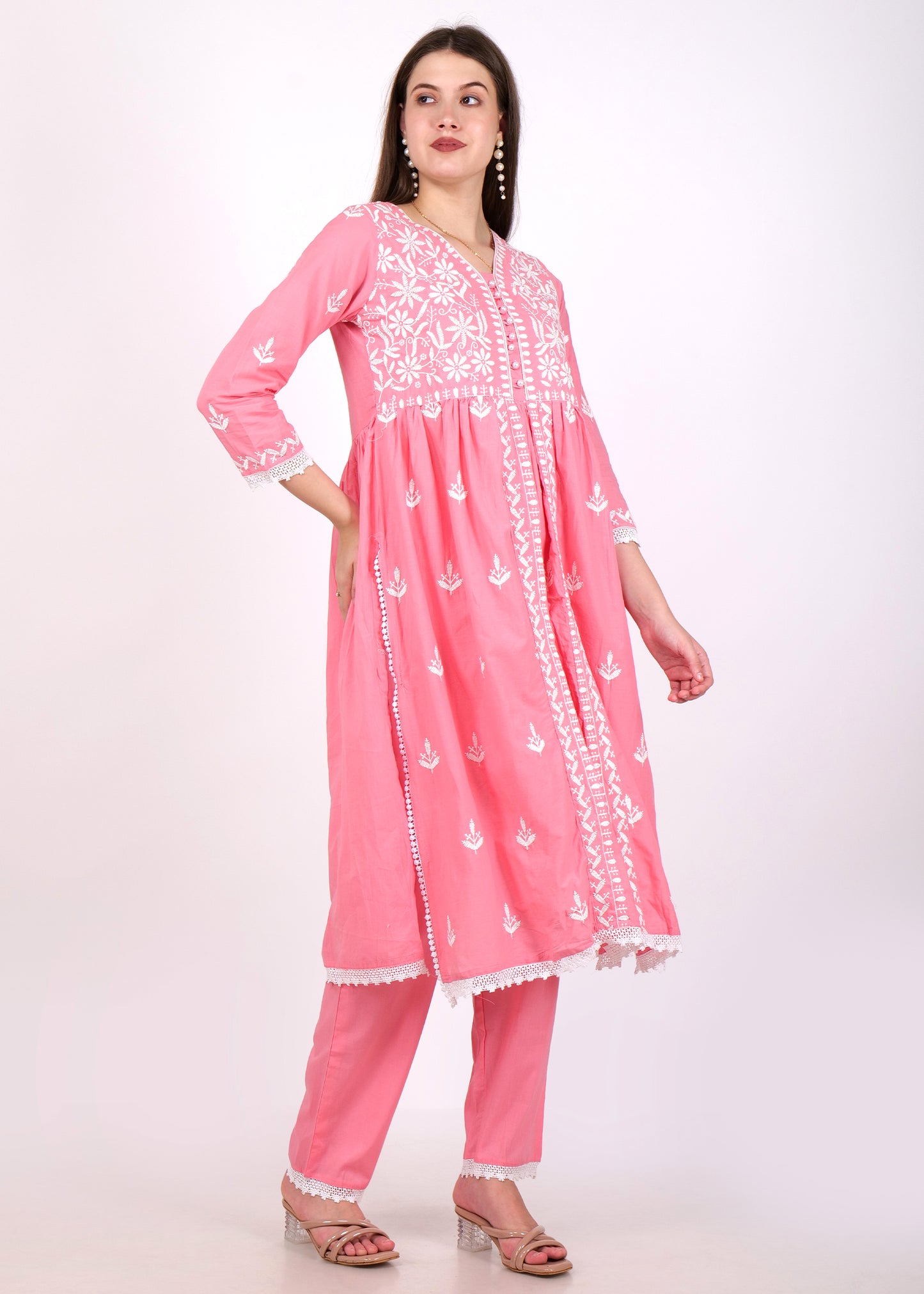 Full-length view of a woman in a pink embroidered Anarkali kurta with intricate white detailing and lace accents.