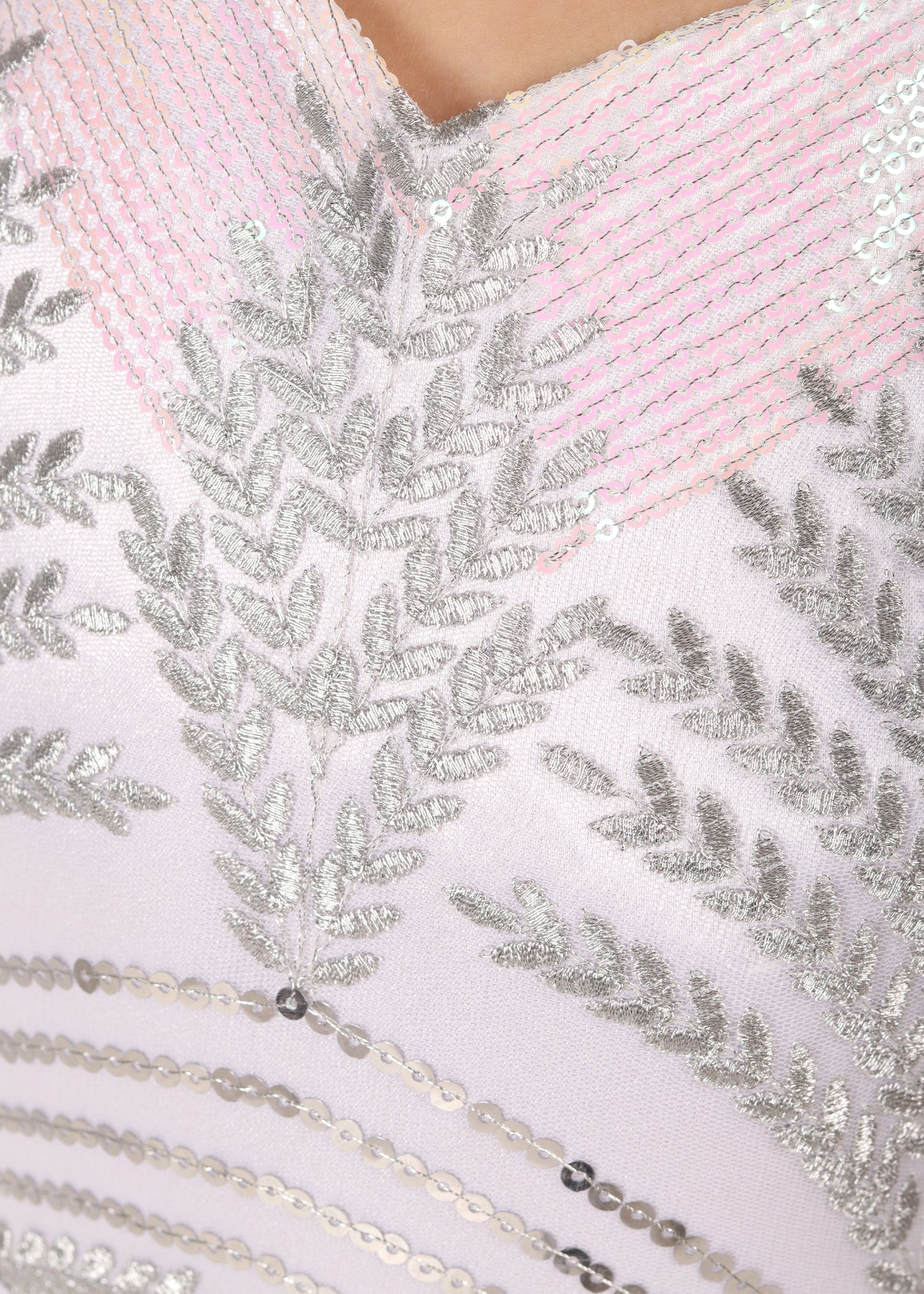 Close-up of silver embroidery and sequin details on a stylish girl's gown, highlighting the craftsmanship and elegance of the fabric.