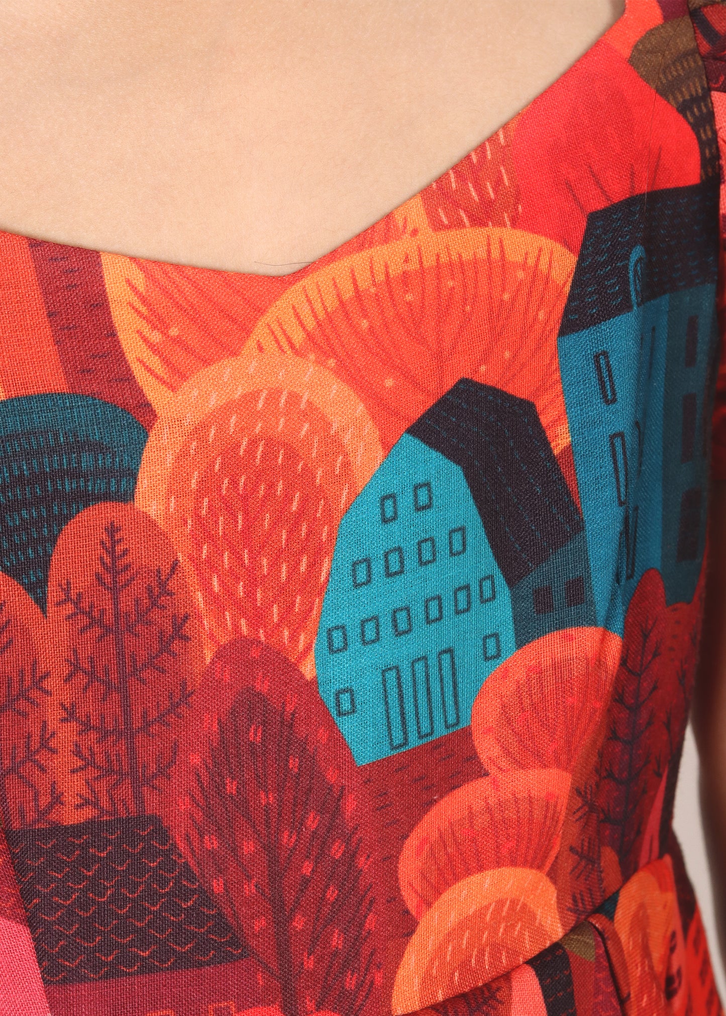 Close-up of a girl's dress featuring a vibrant, detailed house and tree pattern, showcasing the intricate design and colorful print