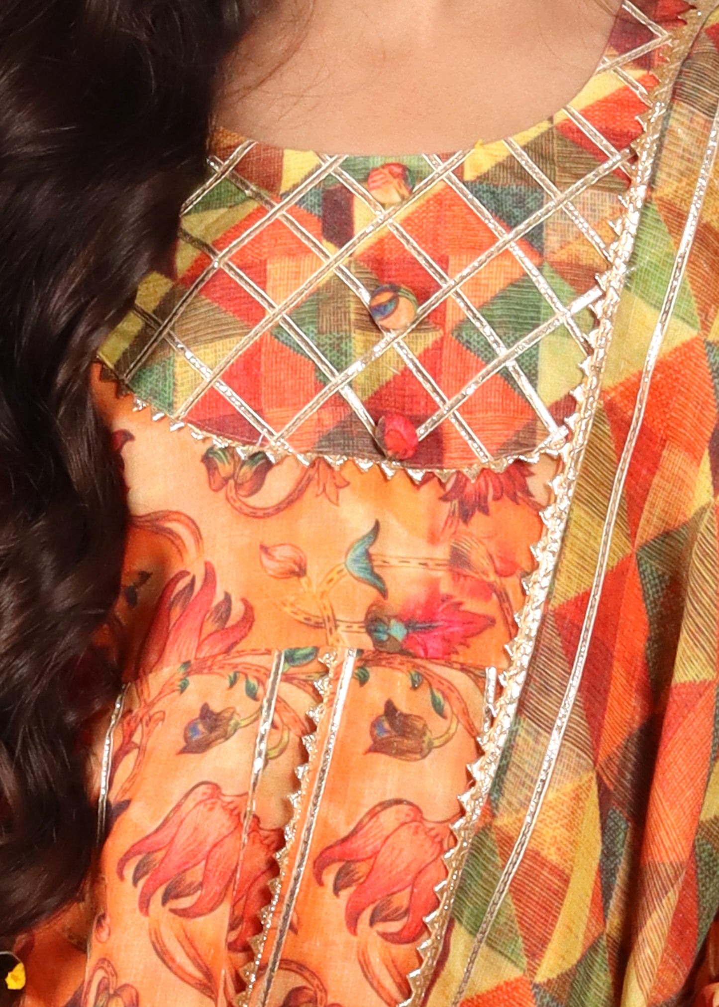 Close-up of a floral embroidered kurta neckline with geometric patterns and gold detailing. The vibrant colors and intricate design make this a perfect traditional wear for festive celebrations.