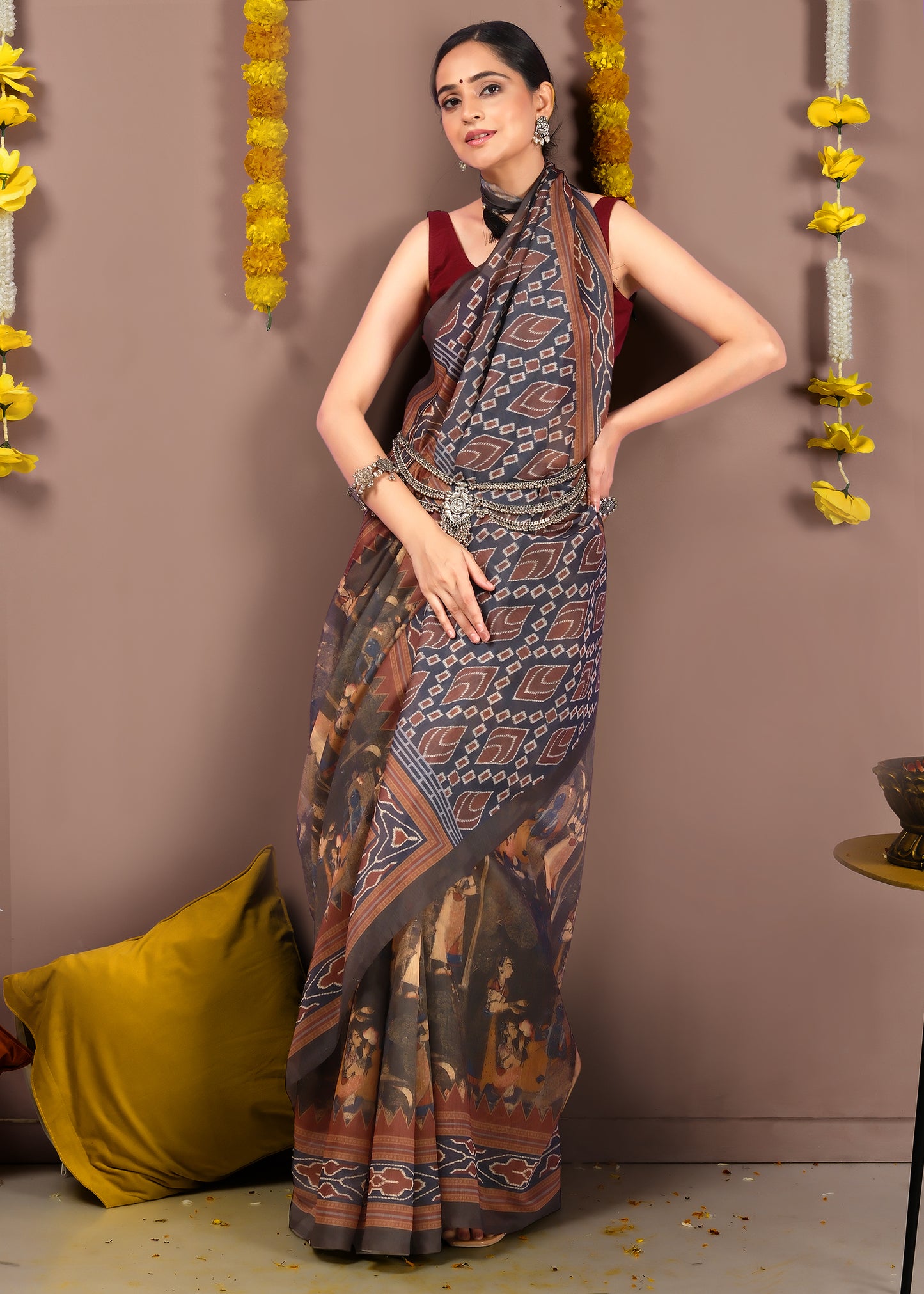 Back view of a model flaunting the detailed pallu of her saree, adorned with tribal-inspired designs and geometric patterns