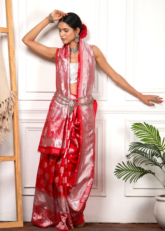 Model posing in a red and silver saree, elegantly styled with silver jewelry, reflecting a modern yet traditional Indian wedding look.