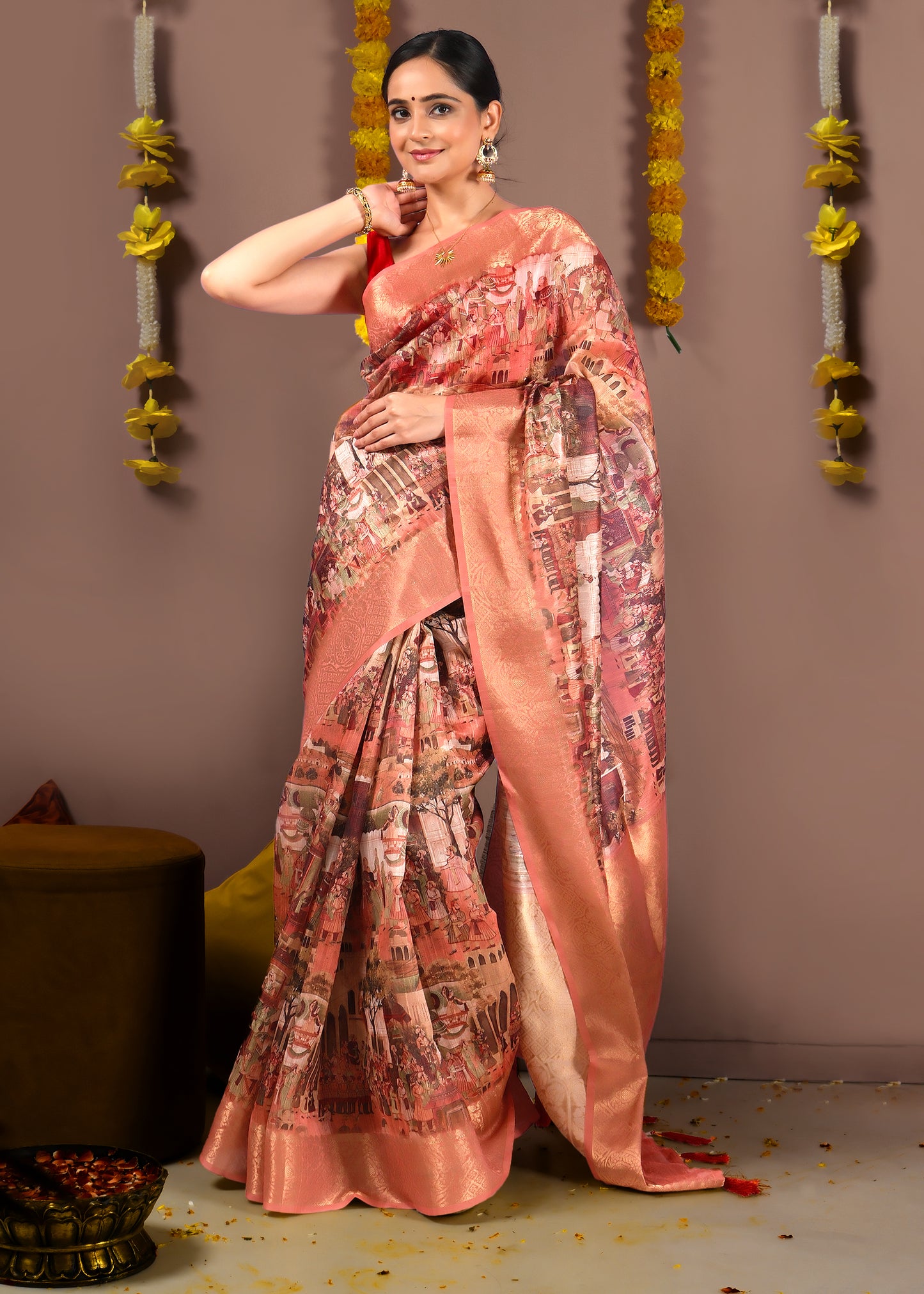 Back view of the model wearing a peach saree, highlighting the cityscape artwork on the pallu and gold zari border.