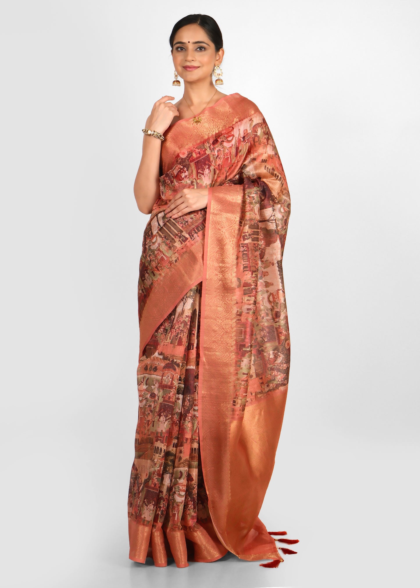 Model displaying a peach cityscape saree with vibrant urban motifs and rich gold zari borders.