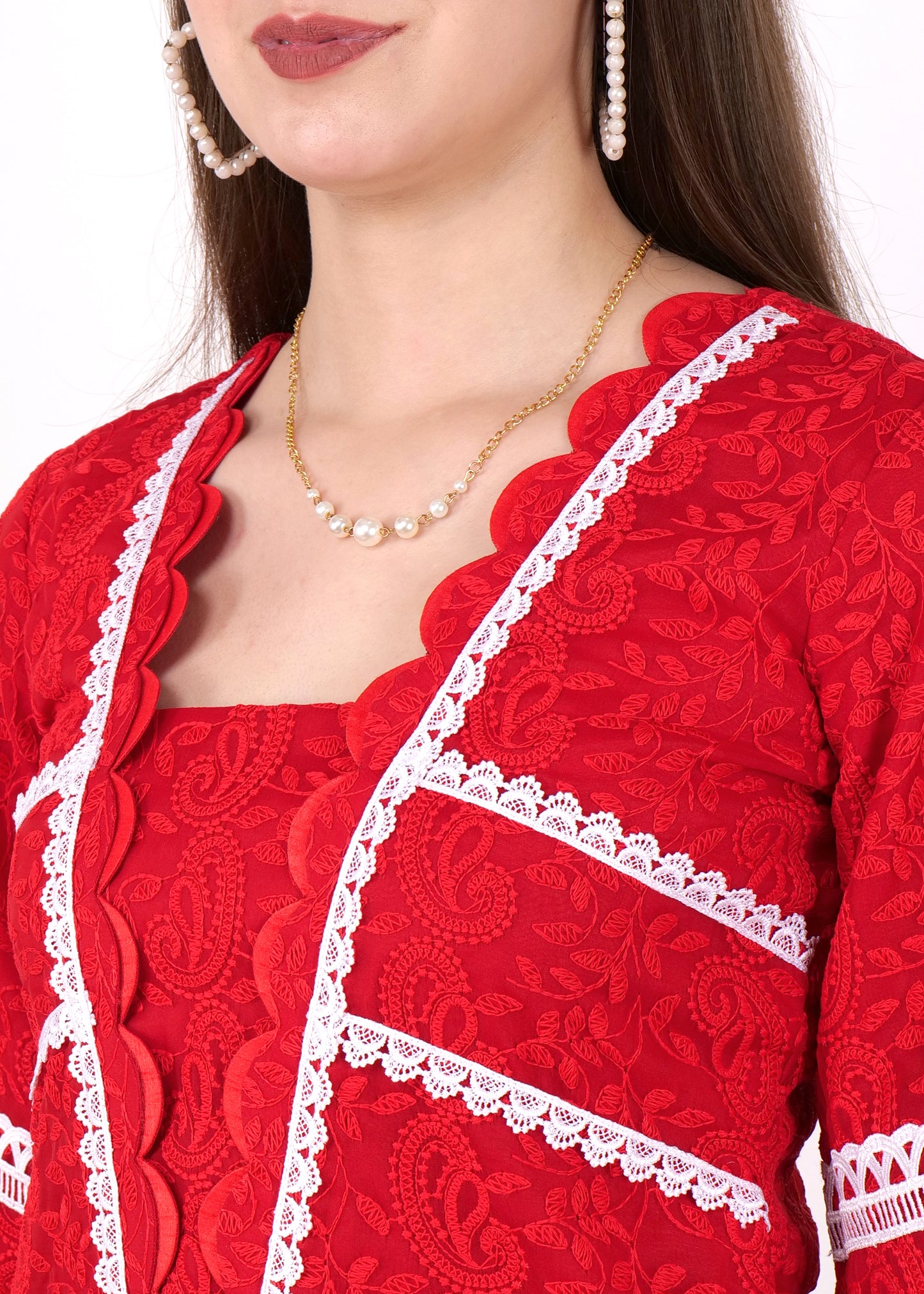 A close-up shot highlighting the delicate lace design and white lace trim on the red kurta, paired with gold and pearl accessories