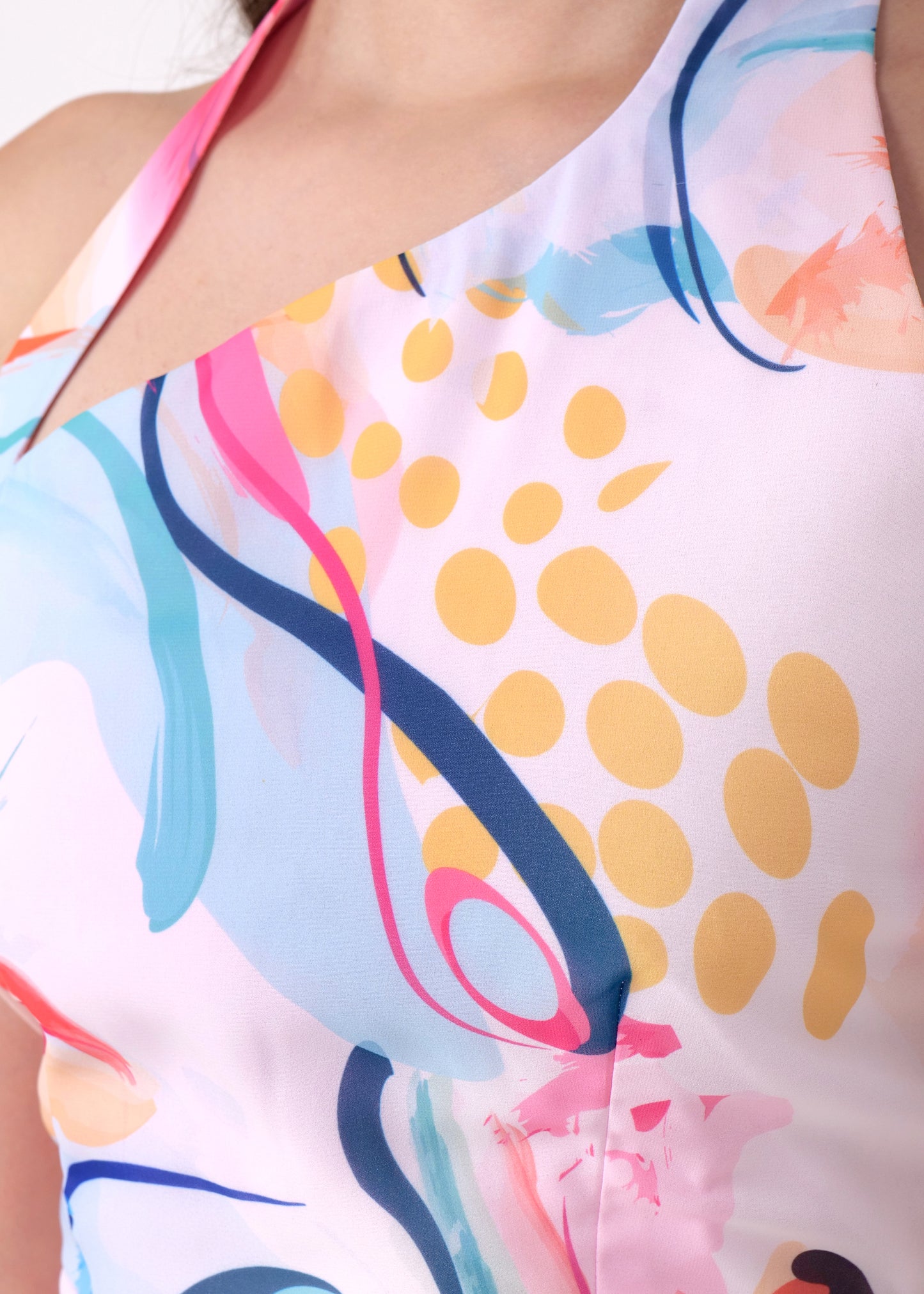 Close-up of the colorful pattern and details on the halter-neck mini dress