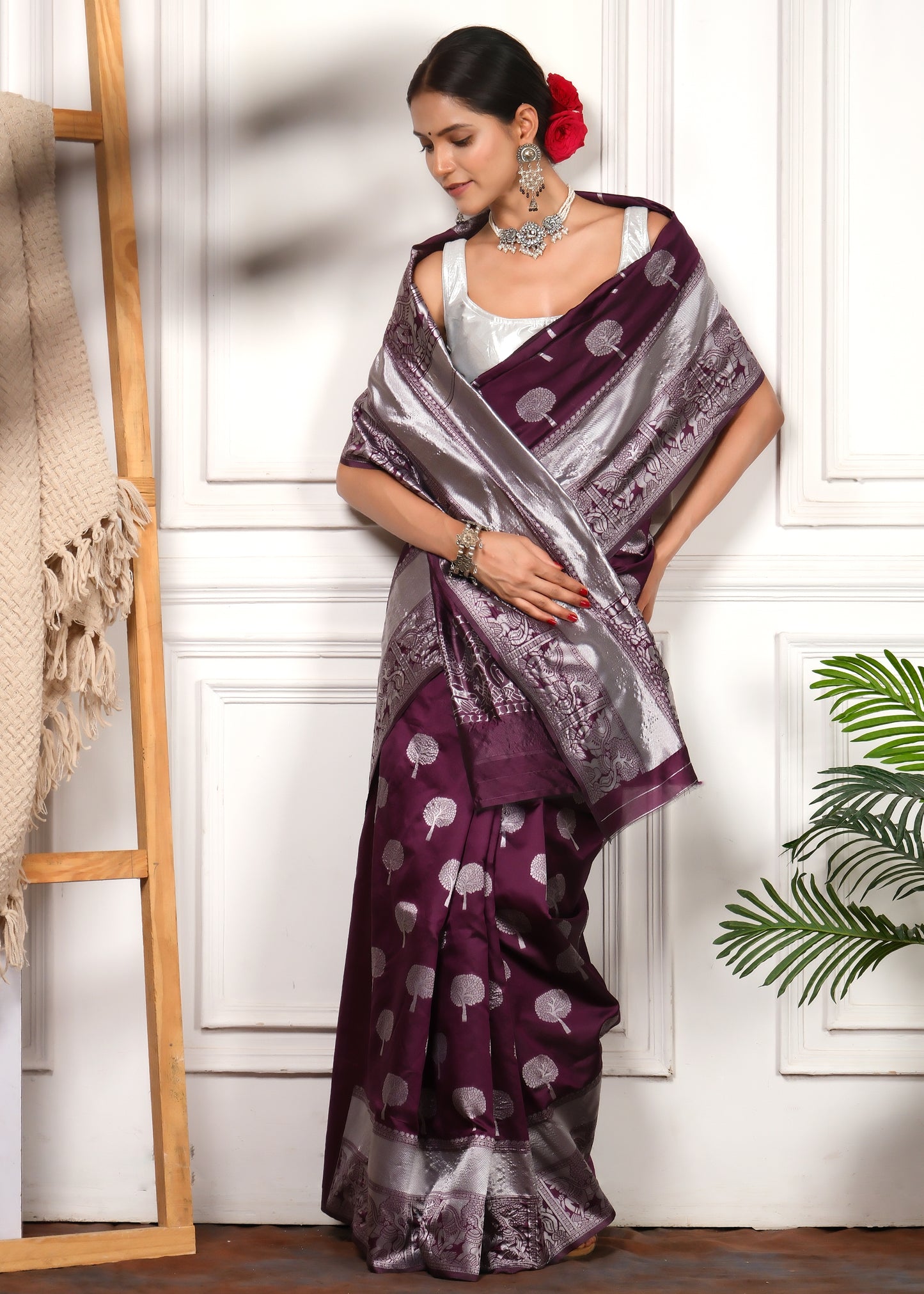 Model in Traditional Purple and Silver Banarasi Saree with Matching Silver Jewelry
The model is seen standing gracefully in a traditional purple Banarasi saree with silver embroidery and broad borders, accentuated by matching silver jewelry.
