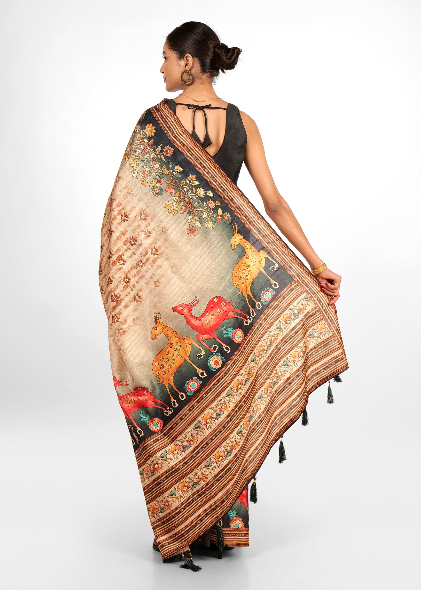 Back view of a model in a beige saree with vibrant animal motifs and floral patterns, ideal for traditional wear.