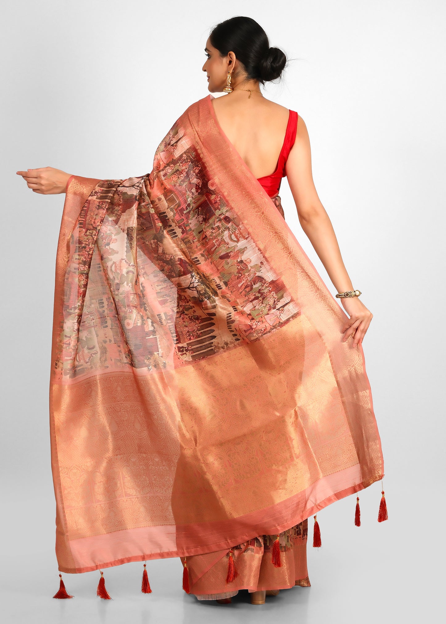 Rear view of the peach cityscape saree with a beautifully draped pallu featuring Indian architecture and subtle gold tones.