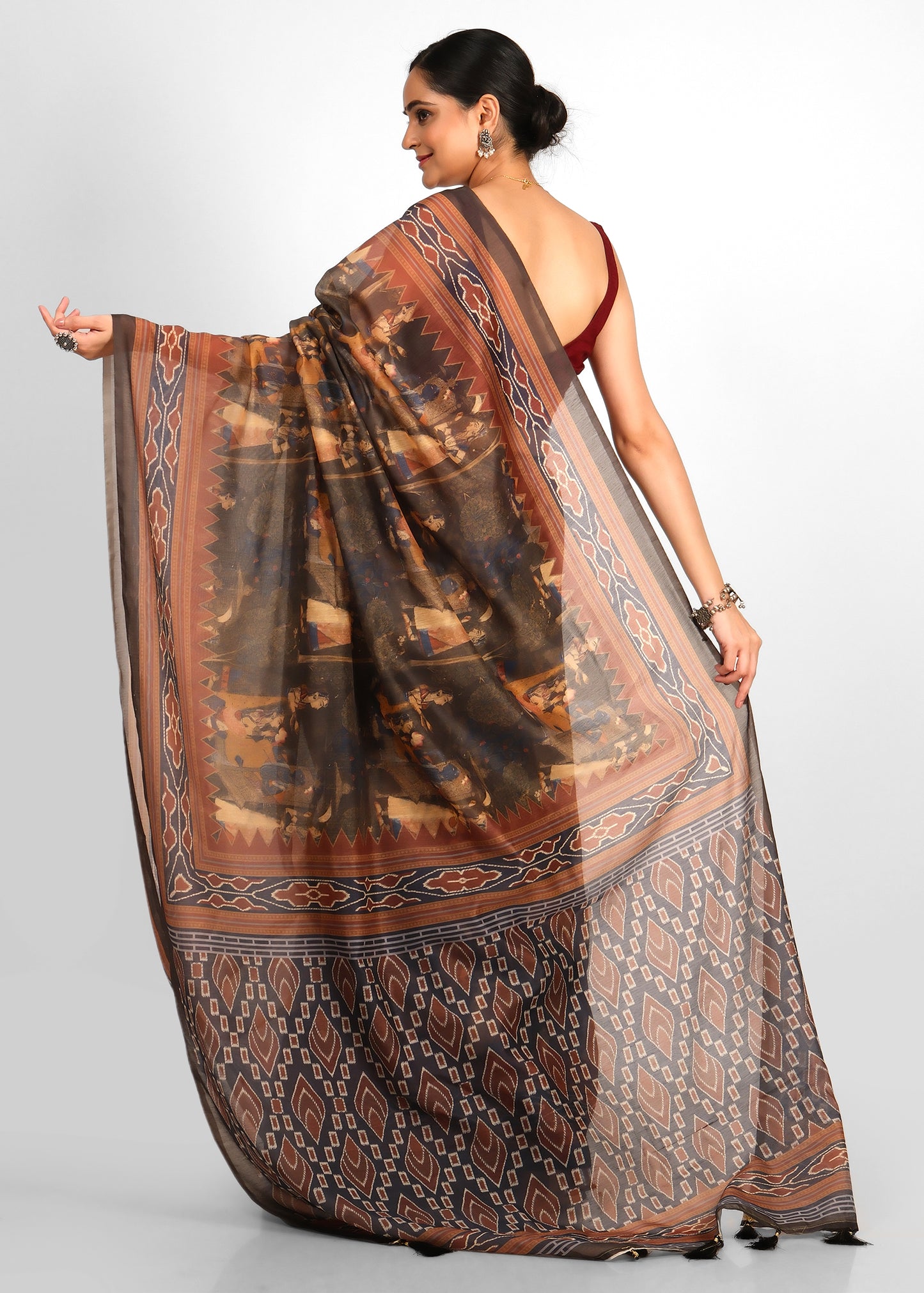 The full intricate pallu showcasing a unique blend of geometric and tribal motifs in shades of brown and earthy hues