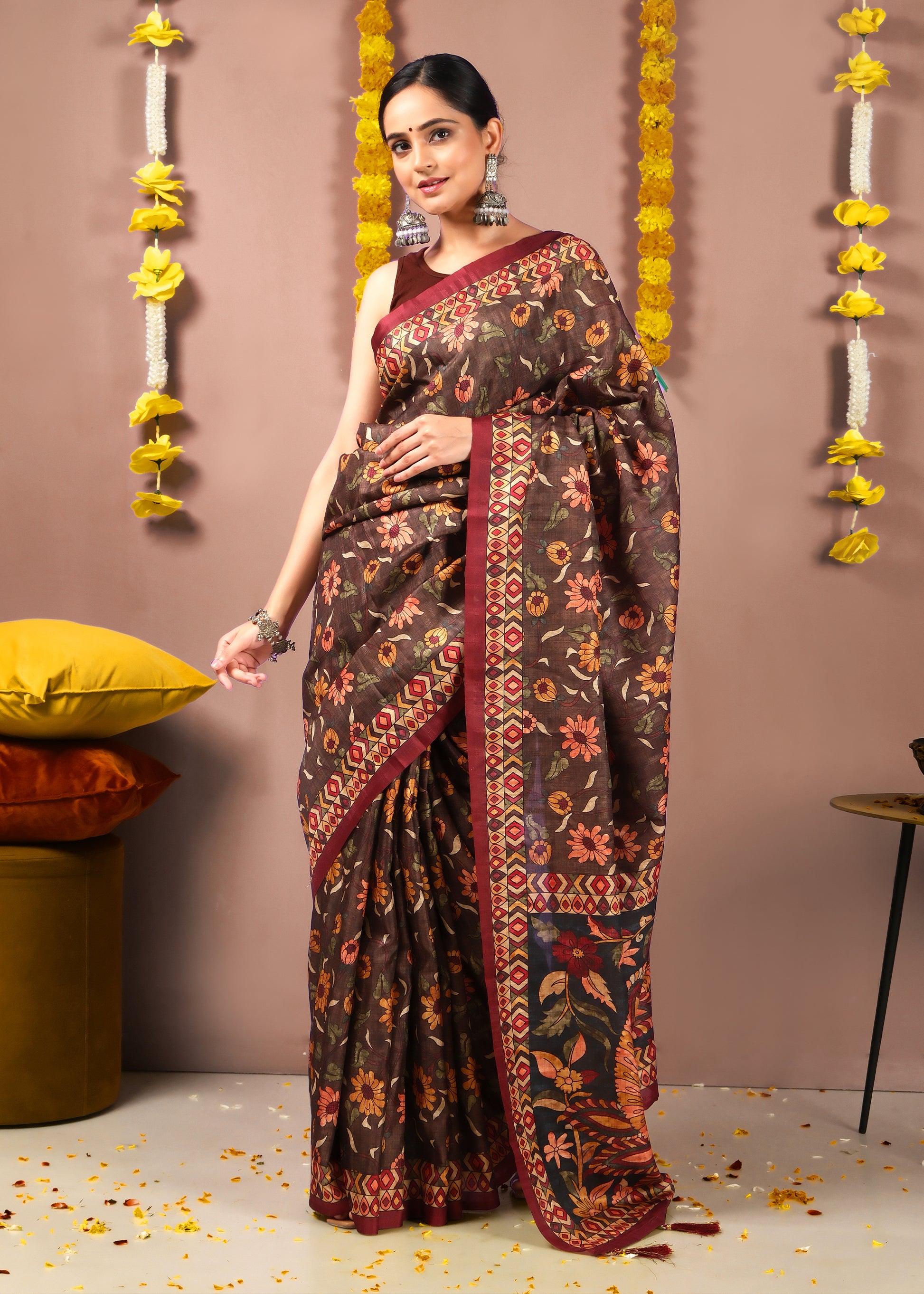 Woman draped in a deep brown saree with traditional floral patterns and red accents, perfect for cultural events and weddings.