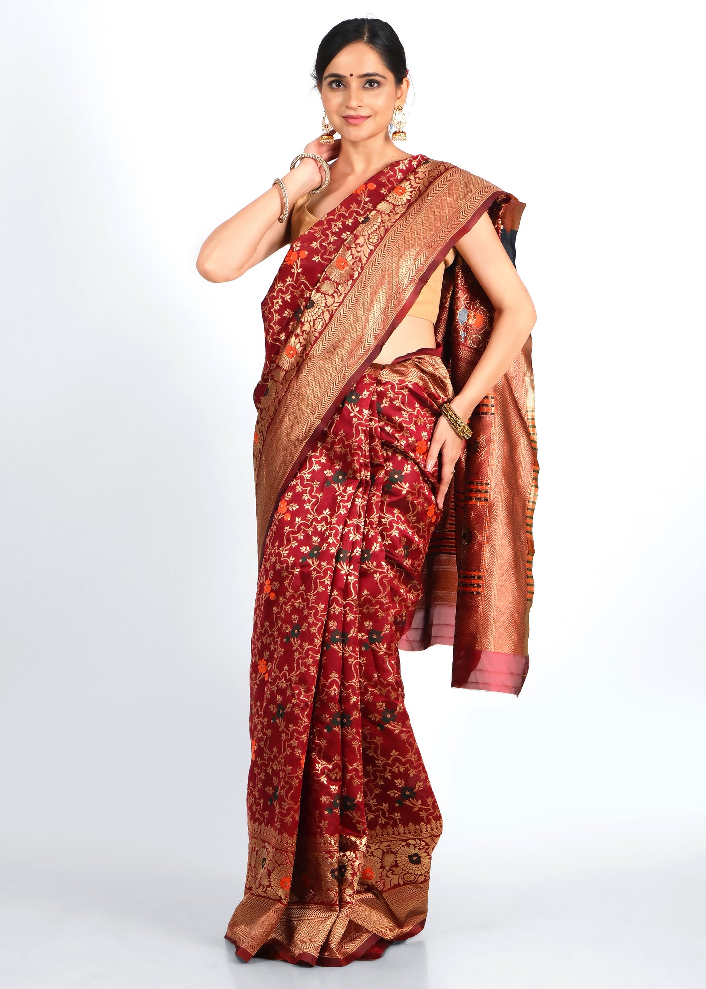 Elegant woman in a luxurious red Banarasi saree with intricate golden floral designs, showcasing a traditional Indian ethnic look