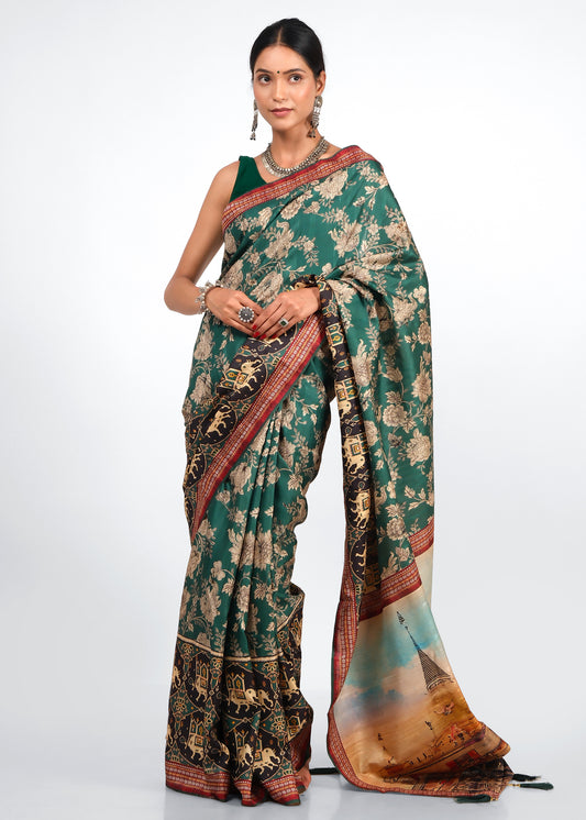 Woman in an elegant green silk saree with golden floral patterns, standing gracefully with silver jewelry complementing the traditional attire