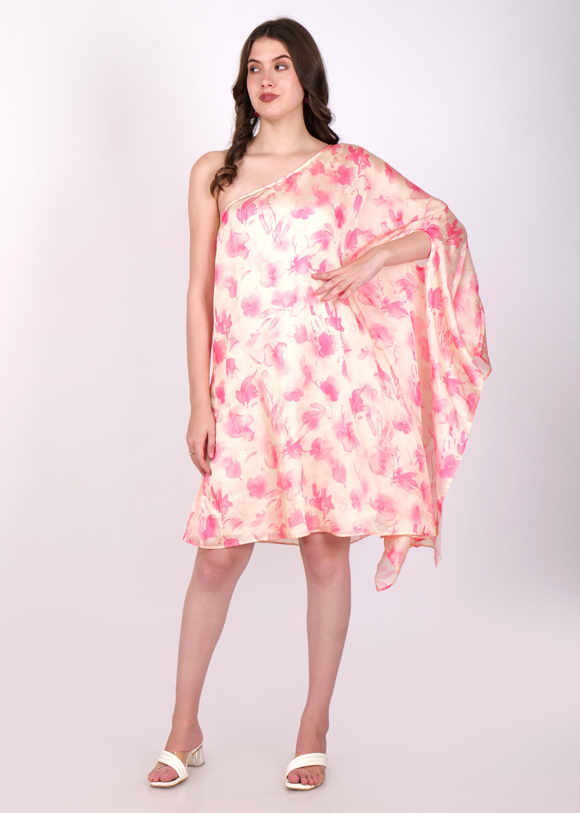 Model wearing an off-shoulder floral dress with pastel pink and peach tones, styled in a one-shoulder design