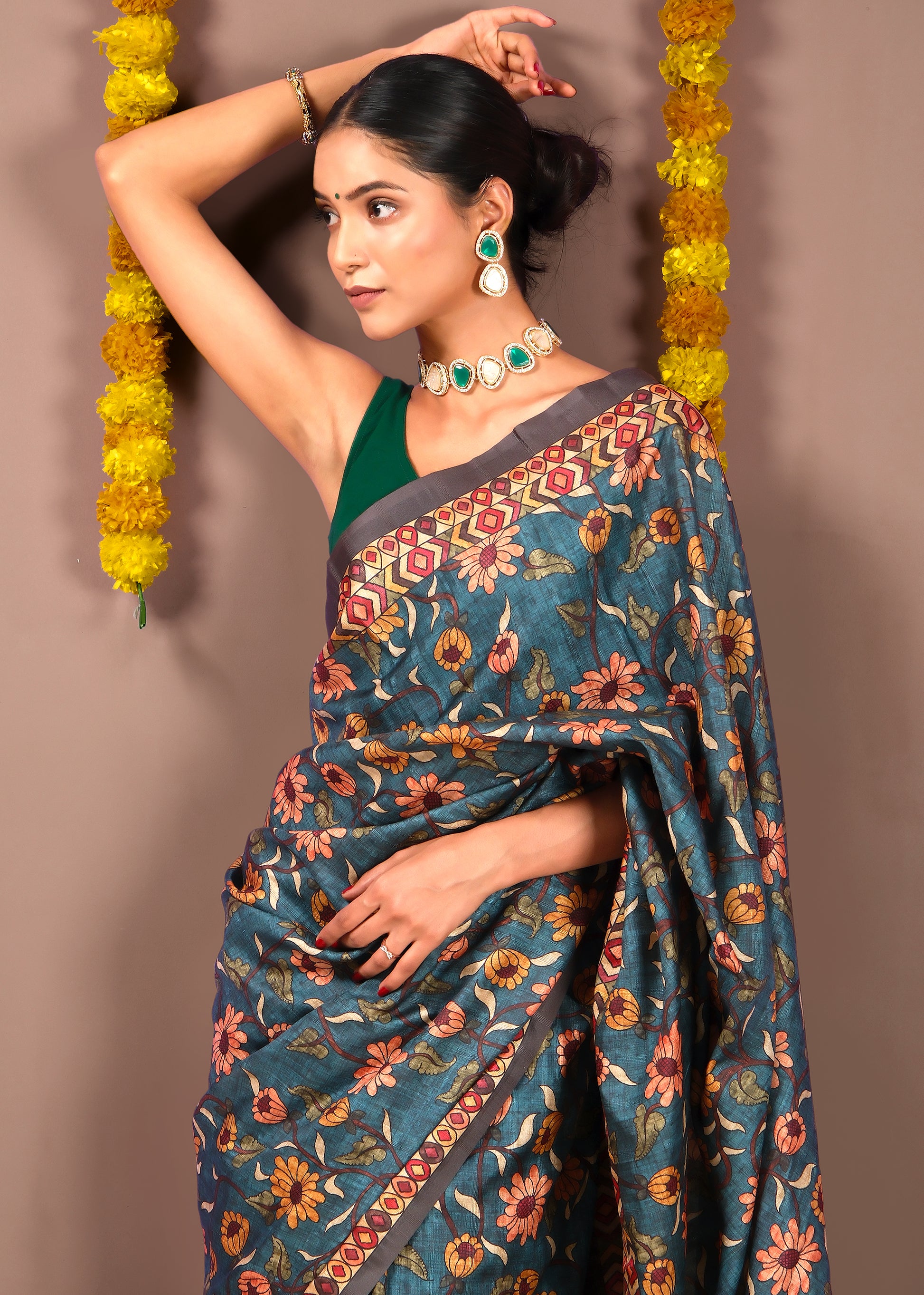 Model posing in blue floral silk saree with intricate border design