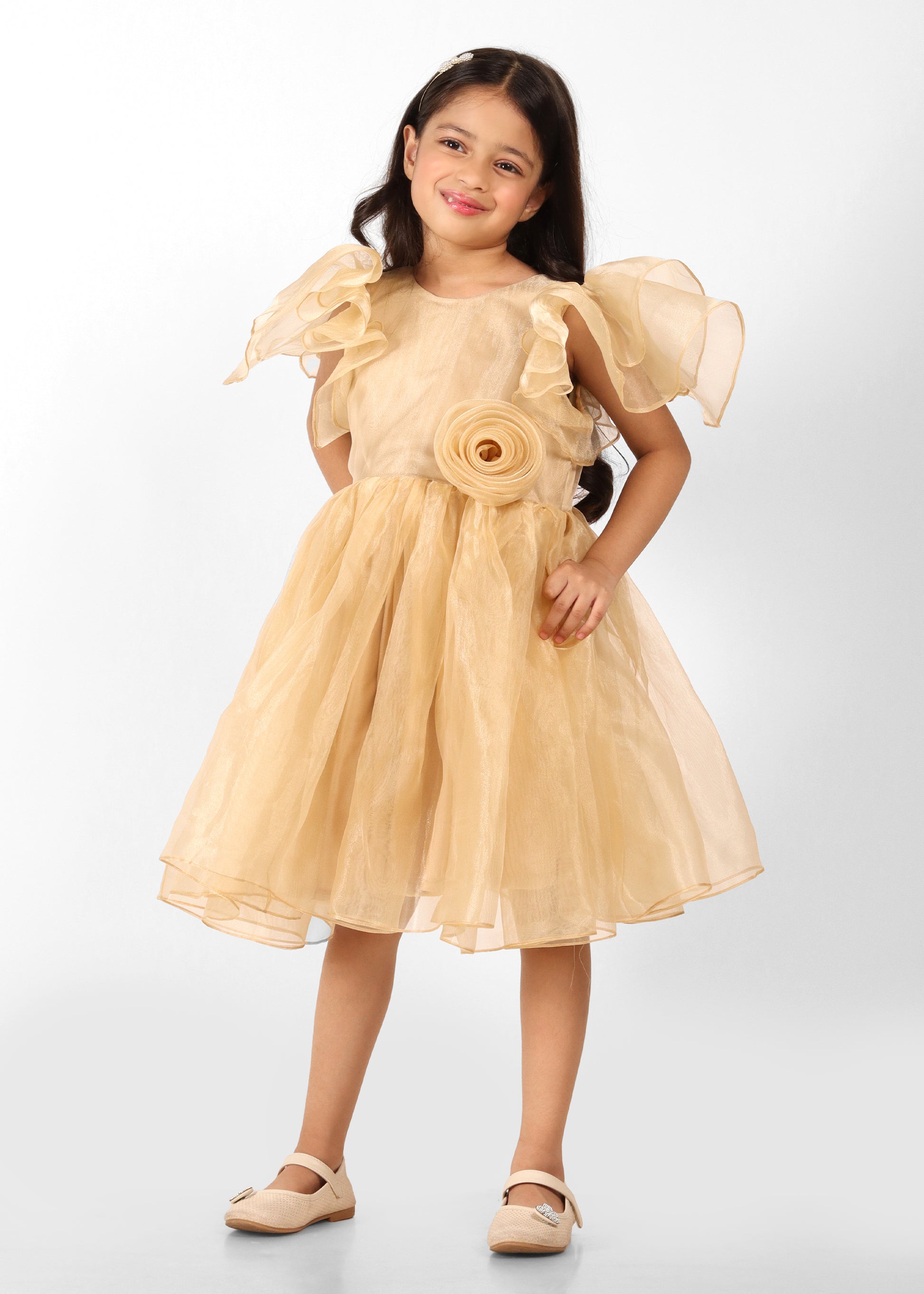 "Full view of a girl wearing a gold dress with organza puff sleeves and a rose detail at the waist, exuding elegance and charm."