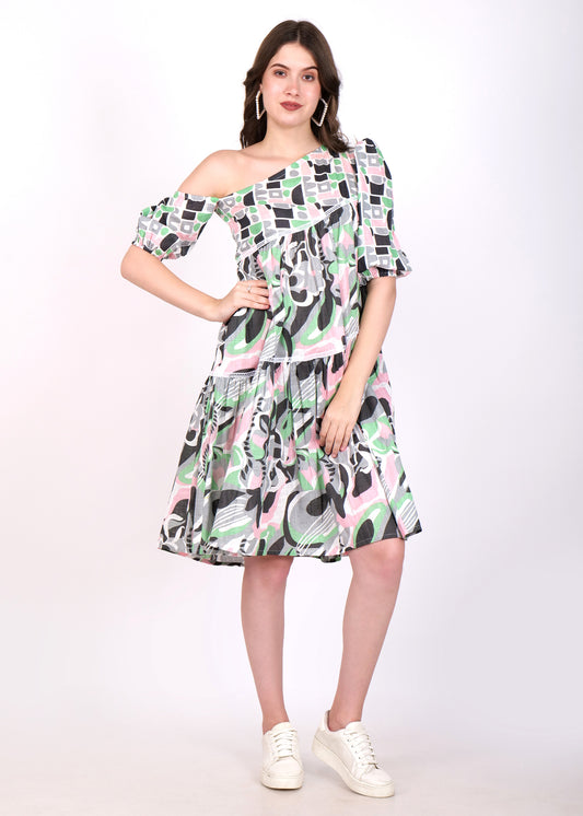 Woman posing in a trendy one-shoulder A-line dress with geometric pastel prints, confidently standing