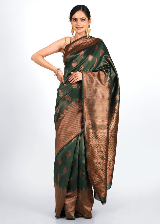 Woman wearing an elegant green and brown traditional silk saree with intricate gold zari work