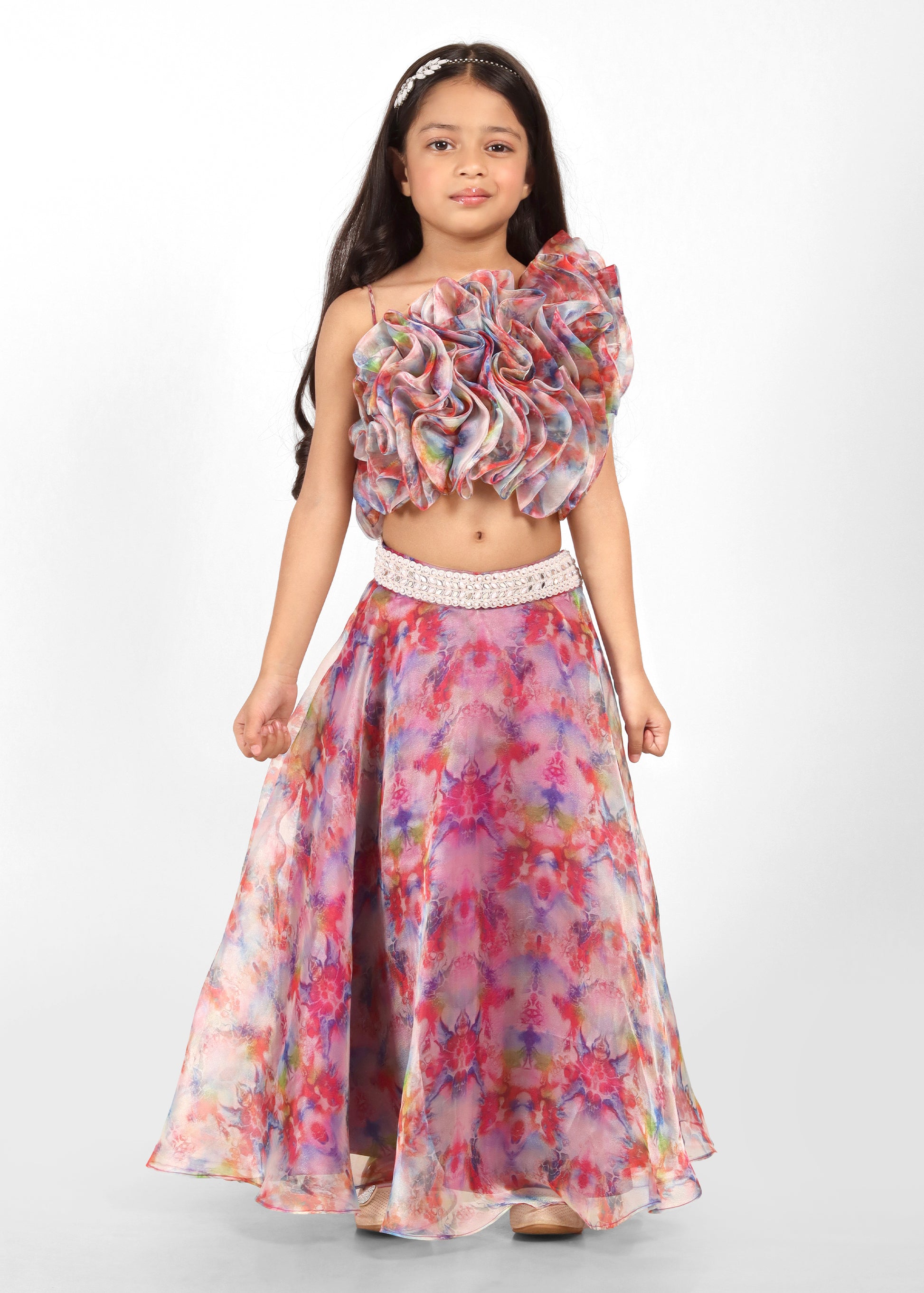 Full view of a girl modeling a floral printed lehenga and ruffle blouse, showing the intricate details and flow of the outfit.