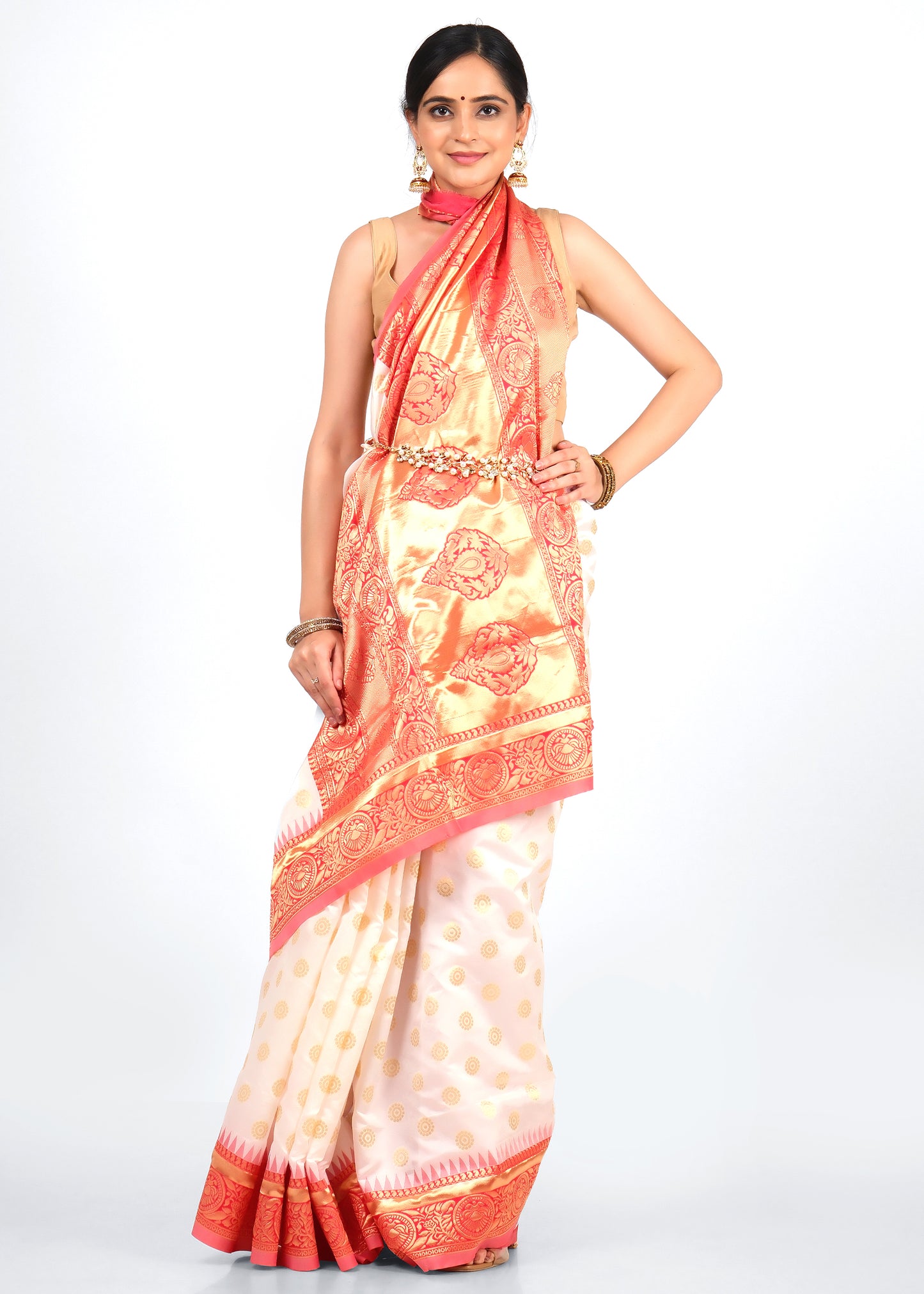 Model wearing a traditional white and orange silk saree with intricate golden zari work, posing front-facing