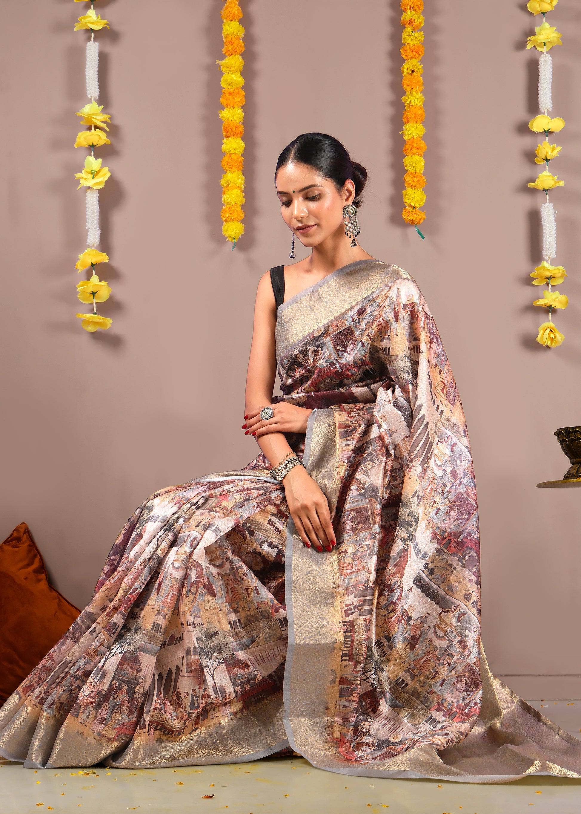 Woman draped in a Mughal-inspired Banarasi silk saree sitting gracefully against a festive backdrop.