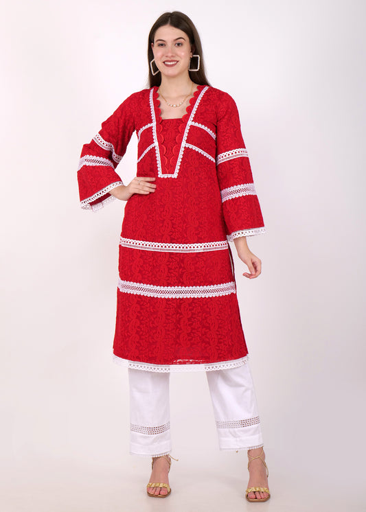 A model wearing a vibrant red lace kurta set adorned with white lace detailing and paired with white embroidered pants