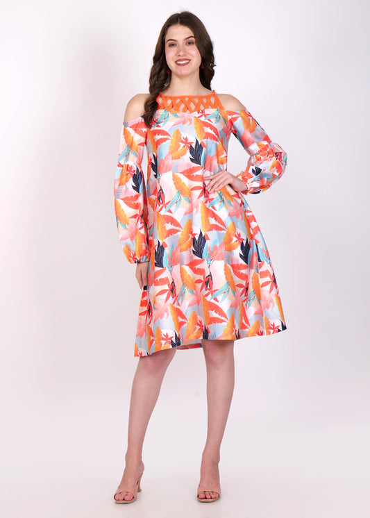 Model in vibrant orange and pink off-shoulder dress with tropical leaf print, standing with a smile