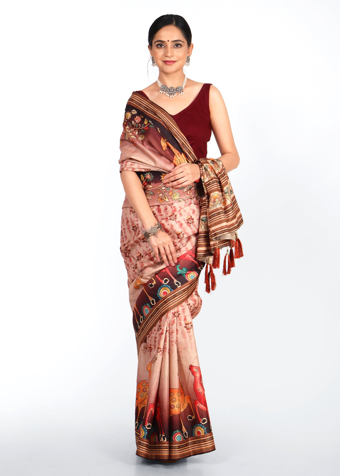 Model wearing a maroon blouse and beige saree with animal motifs and floral designs