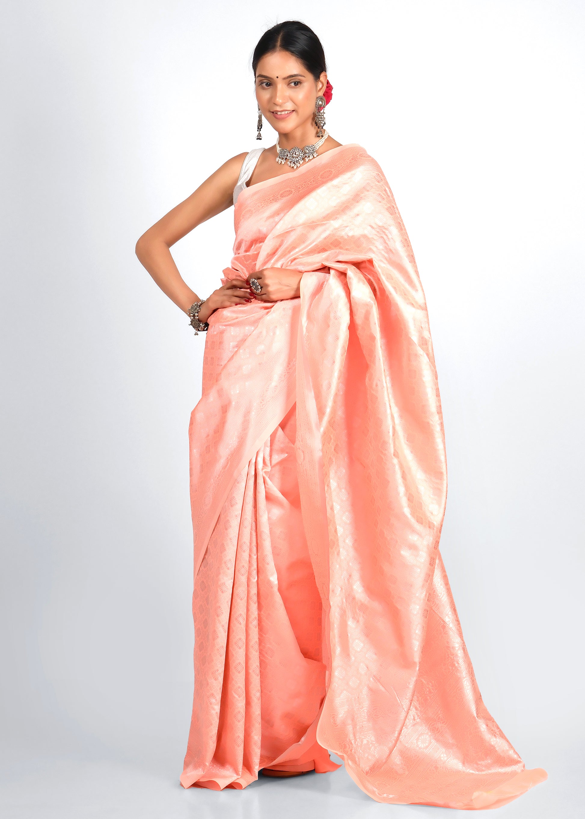 Woman in a beautiful soft pink Banarasi silk saree with intricate woven patterns, styled with silver oxidized jewelry