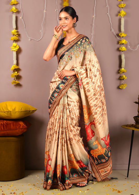 Woman wearing a beige saree with intricate floral embroidery on the pallu, decorated with vibrant horse and deer motifs, styled for a festive occasion.