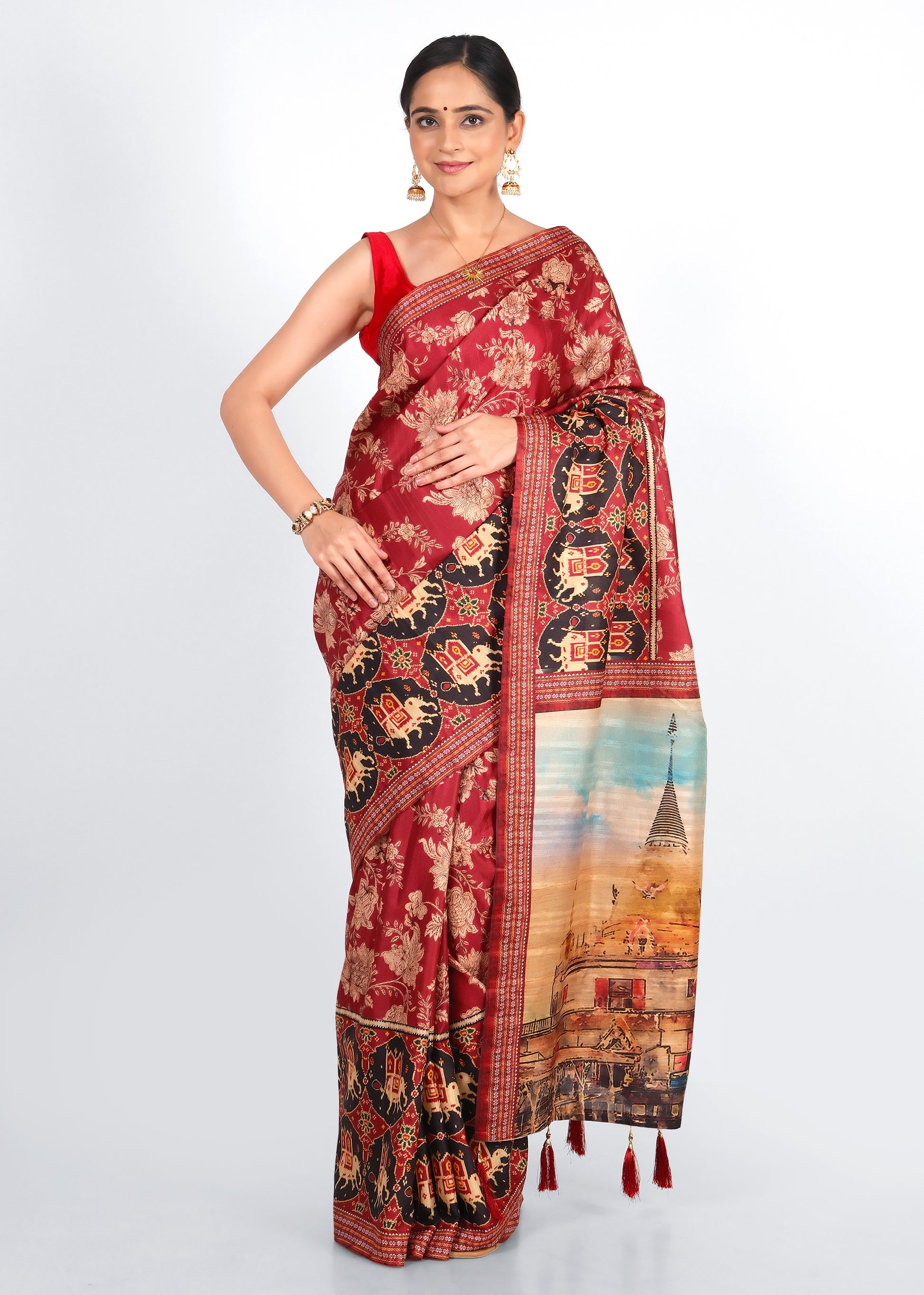 Woman wearing a red saree with intricate floral designs and temple motif, complemented by traditional jewelry and a vibrant backdrop.