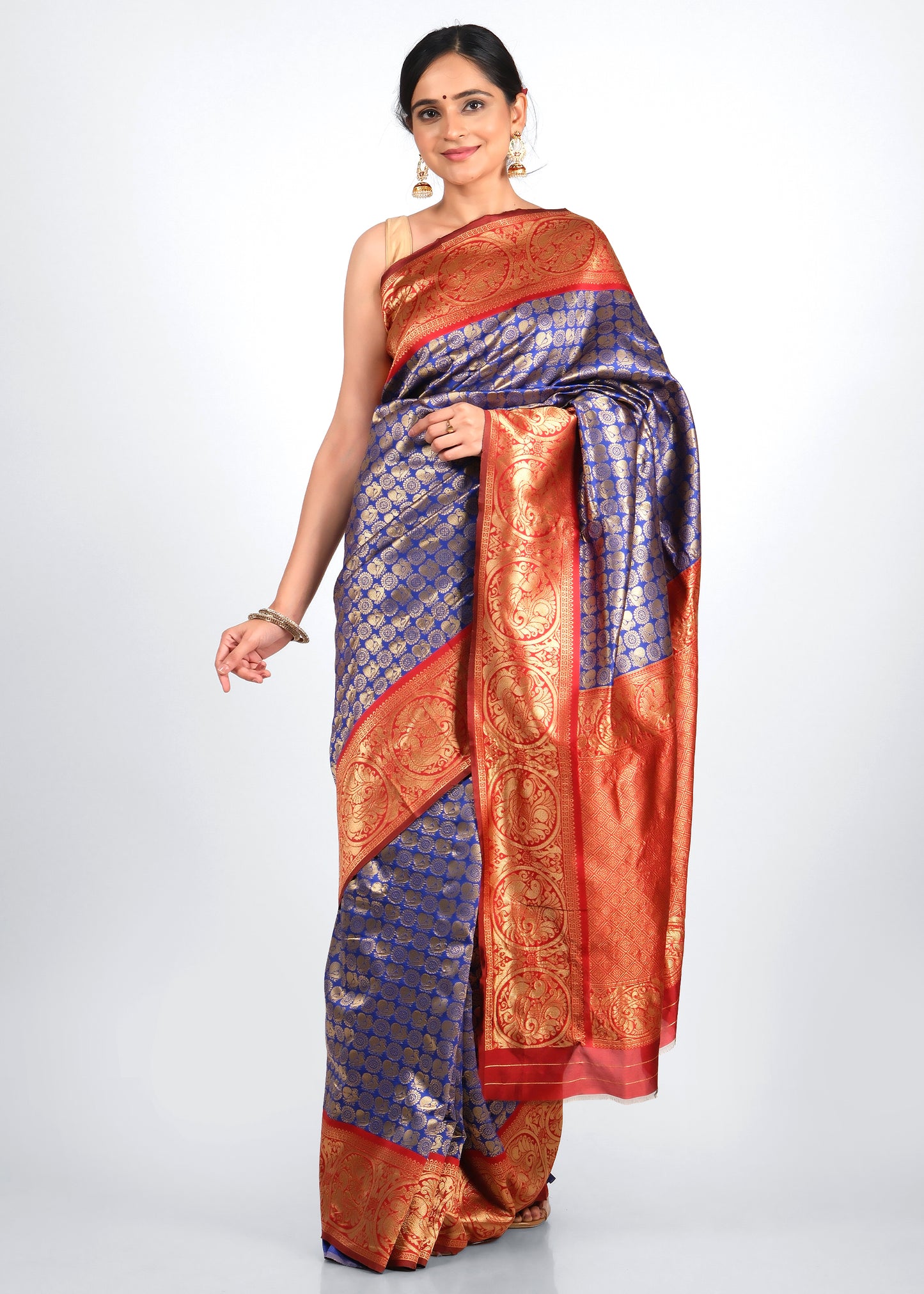 Model wearing a royal blue and red Banarasi silk saree with intricate gold zari work, perfect for traditional weddings and festive occasions