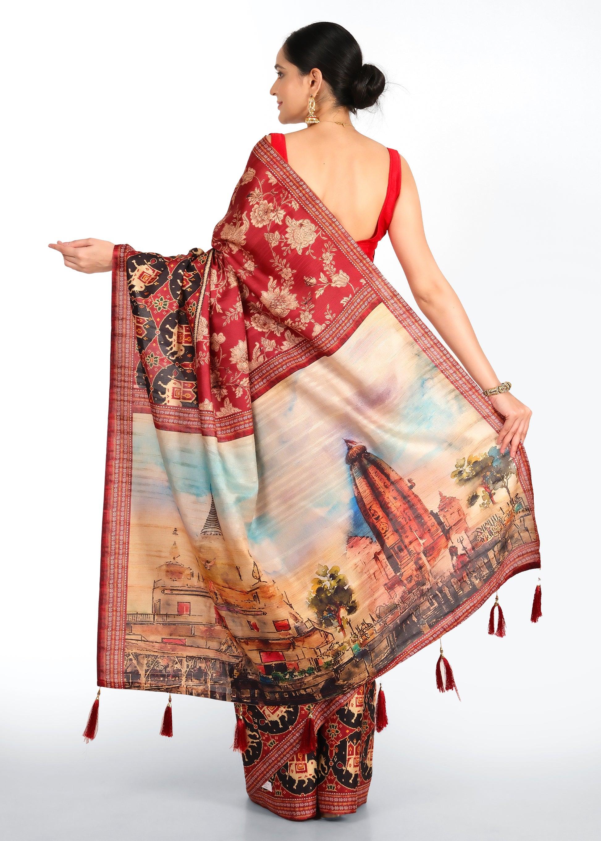 Model showcasing the back of the red saree, featuring a colorful temple design and golden floral patterns.