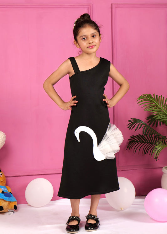 Girl in a black asymmetrical dress with white swan applique posing confidently against a pink background