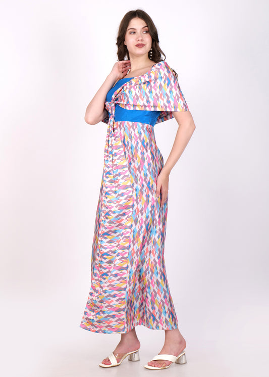 Side profile of the model in a geometric print maxi dress showcasing the off-shoulder drape and vibrant colors