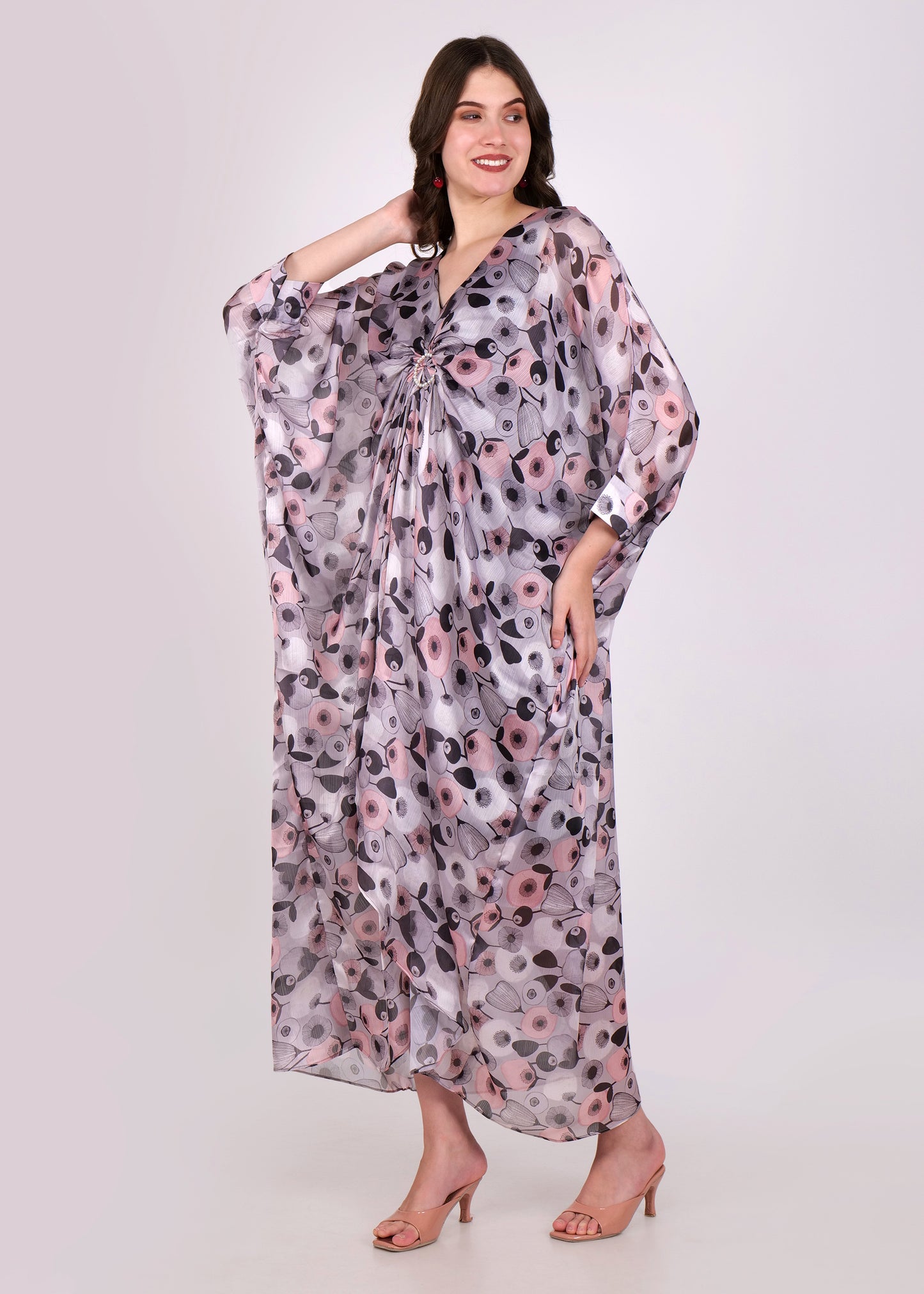 Side view of the woman in the elegant floral kaftan, showing the draped fabric and relaxed, oversized fit for a chic, comfortable look.