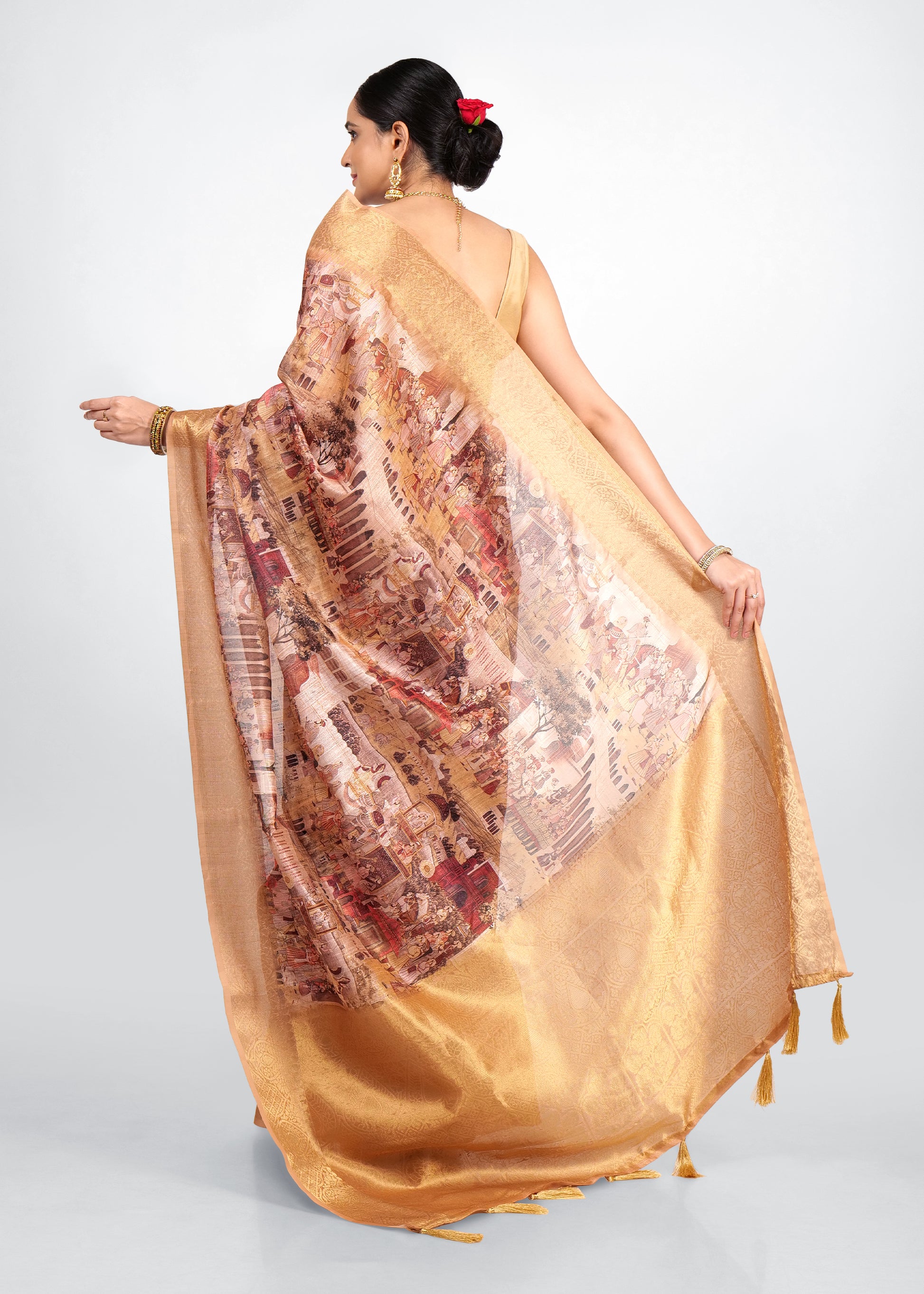 Back view of a model showcasing the flowing pallu of a golden Banarasi saree with intricate Krishna Rasleela prints, giving a glimpse of the detailed artistry