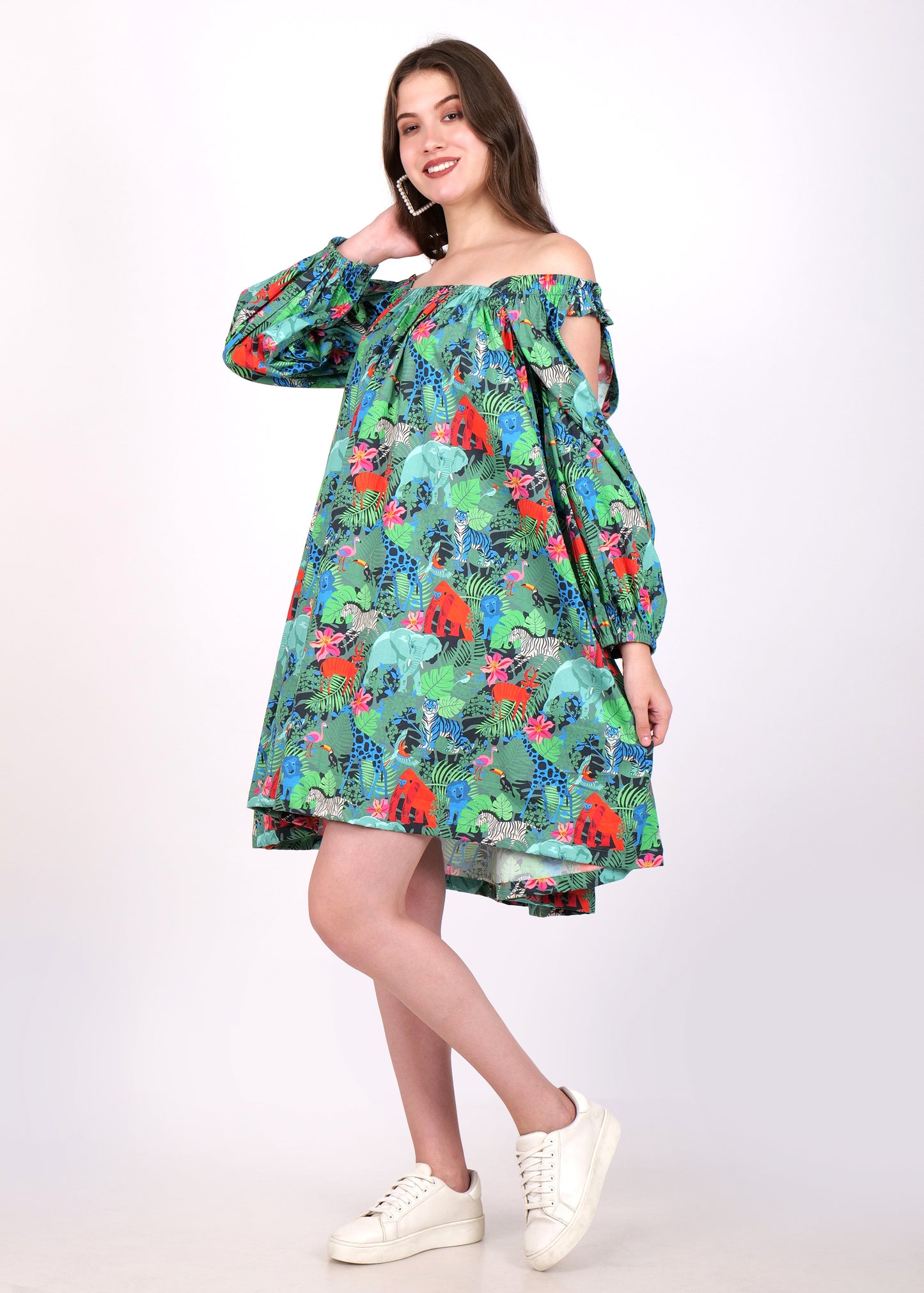 Stylish woman in a green off-shoulder dress with long sleeves and colorful animal prints, casually adjusting her hair