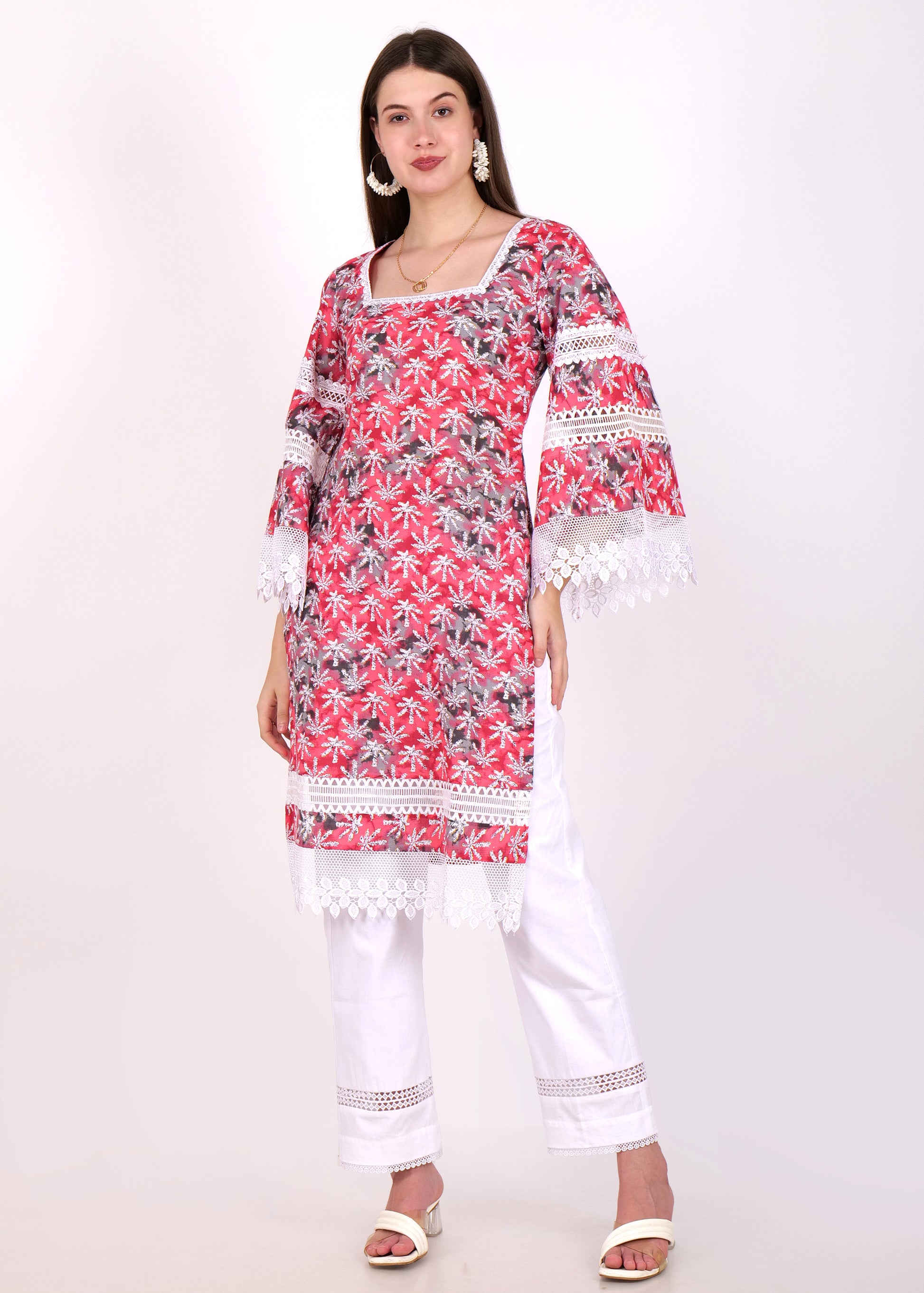 "Front view of a model wearing a floral red kurti with lace detailing, styled with white pants"